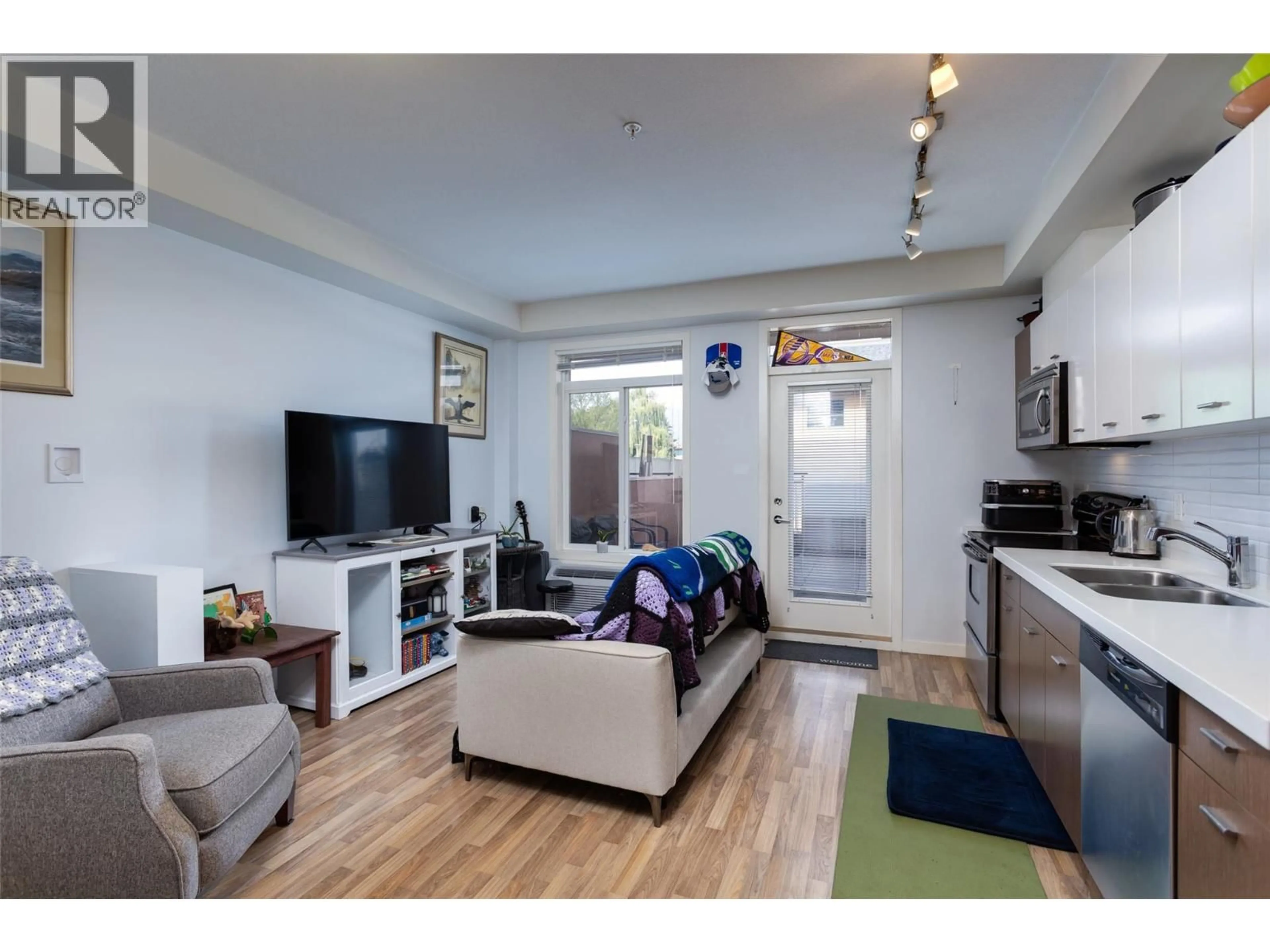 Living room with furniture, wood/laminate floor for 116 - 1550 DICKSON AVENUE, Kelowna British Columbia V1Y9Y8