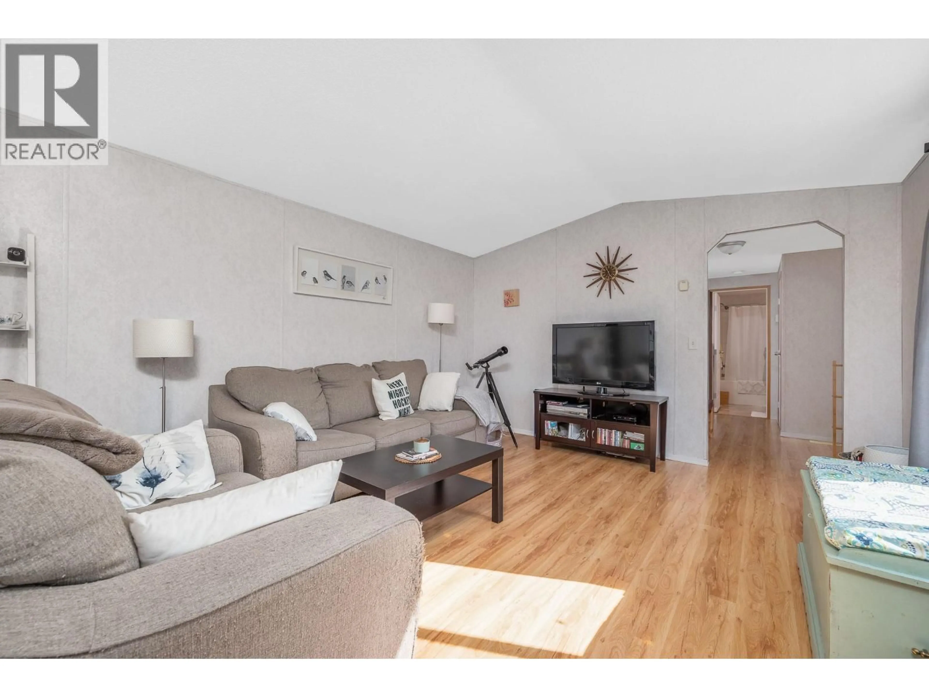 Living room with furniture, wood/laminate floor for 75 - 12560 WESTSIDE ROAD, Vernon British Columbia V1H1S9
