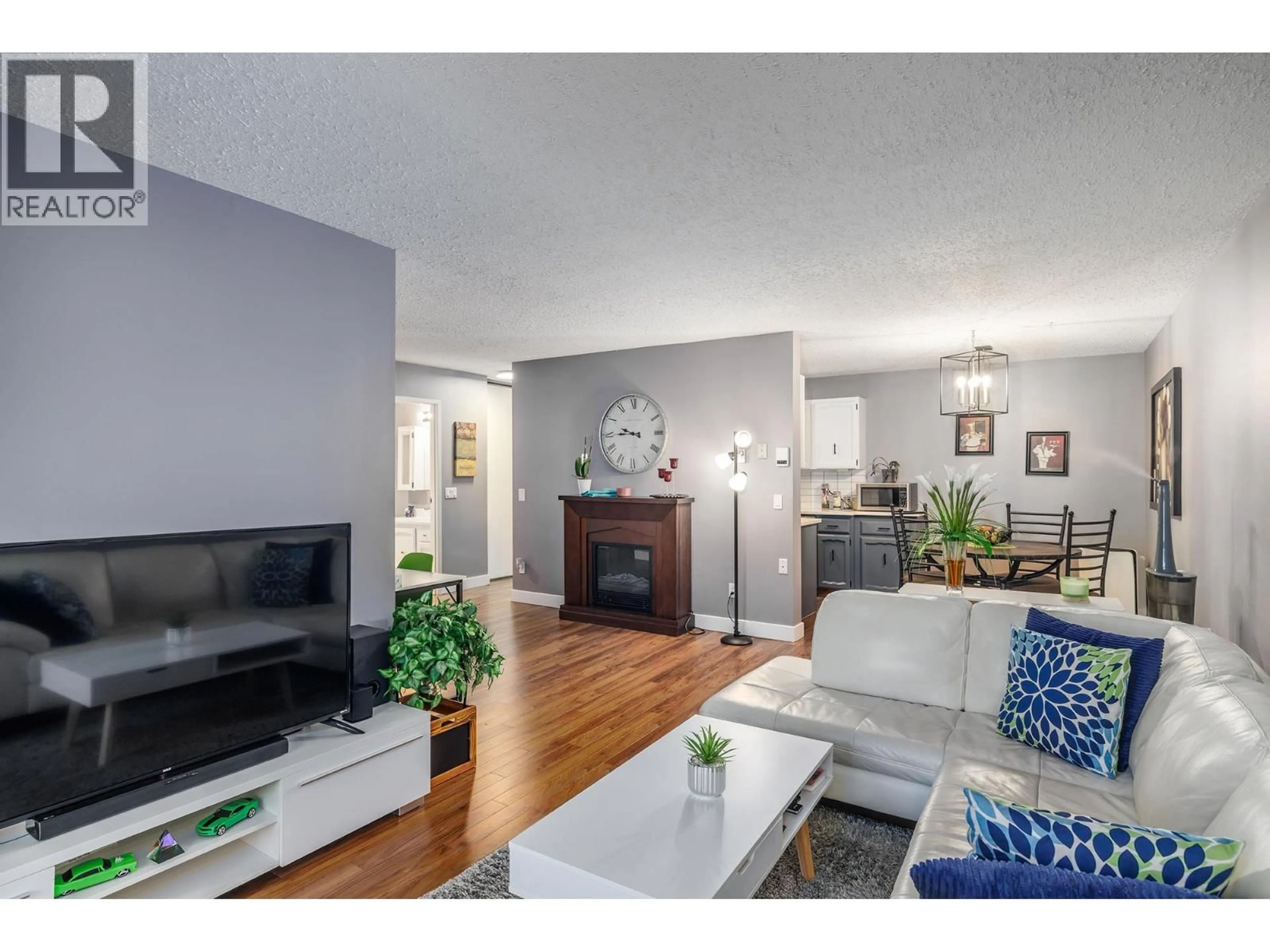 Living room with furniture, wood/laminate floor for 307 - 555 ROWCLIFFE AVENUE, Kelowna British Columbia V1Y5Y8