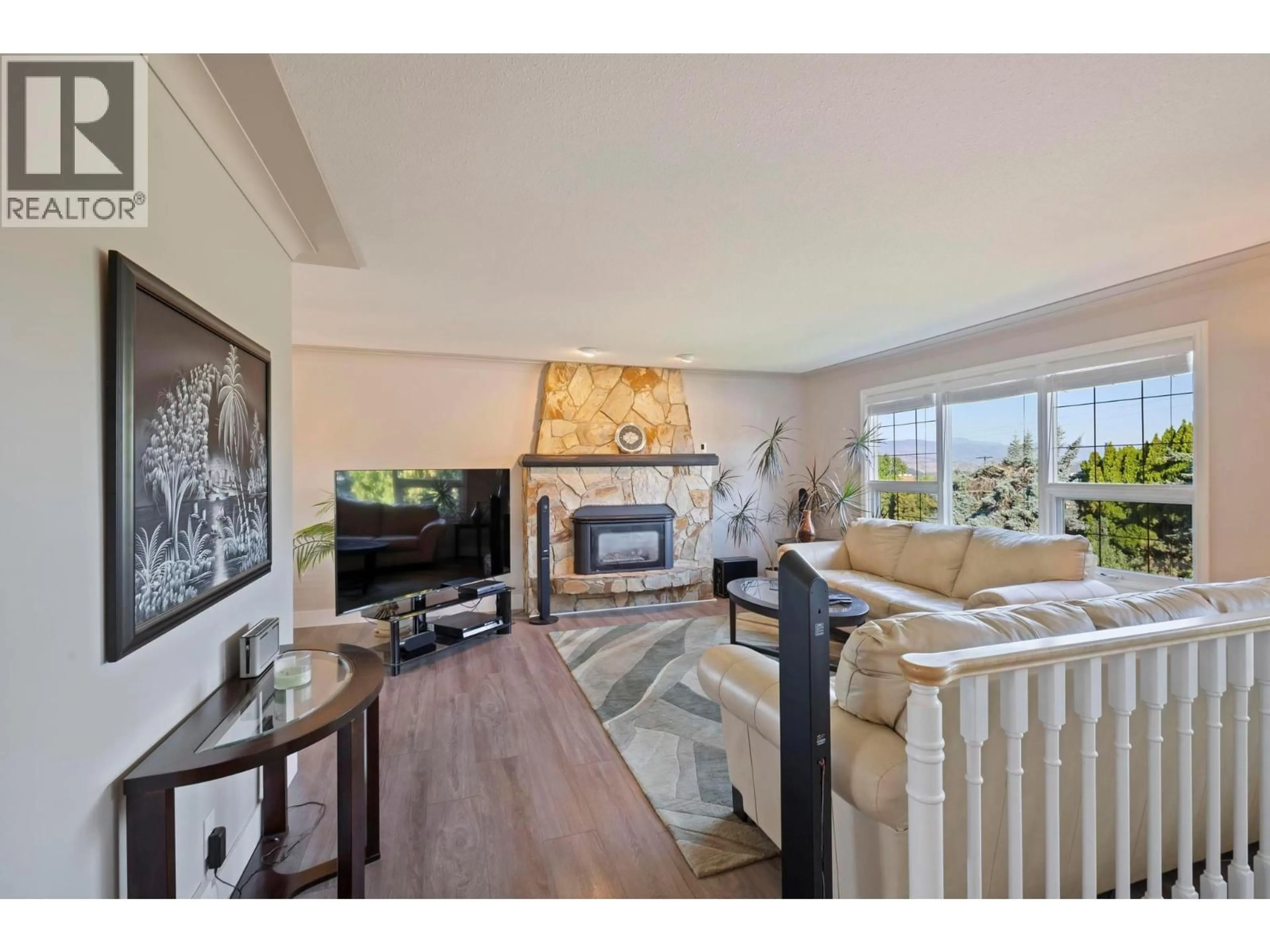 Living room with furniture, wood/laminate floor for 1685 JONATHAN ROAD, Kelowna British Columbia V1P1A7
