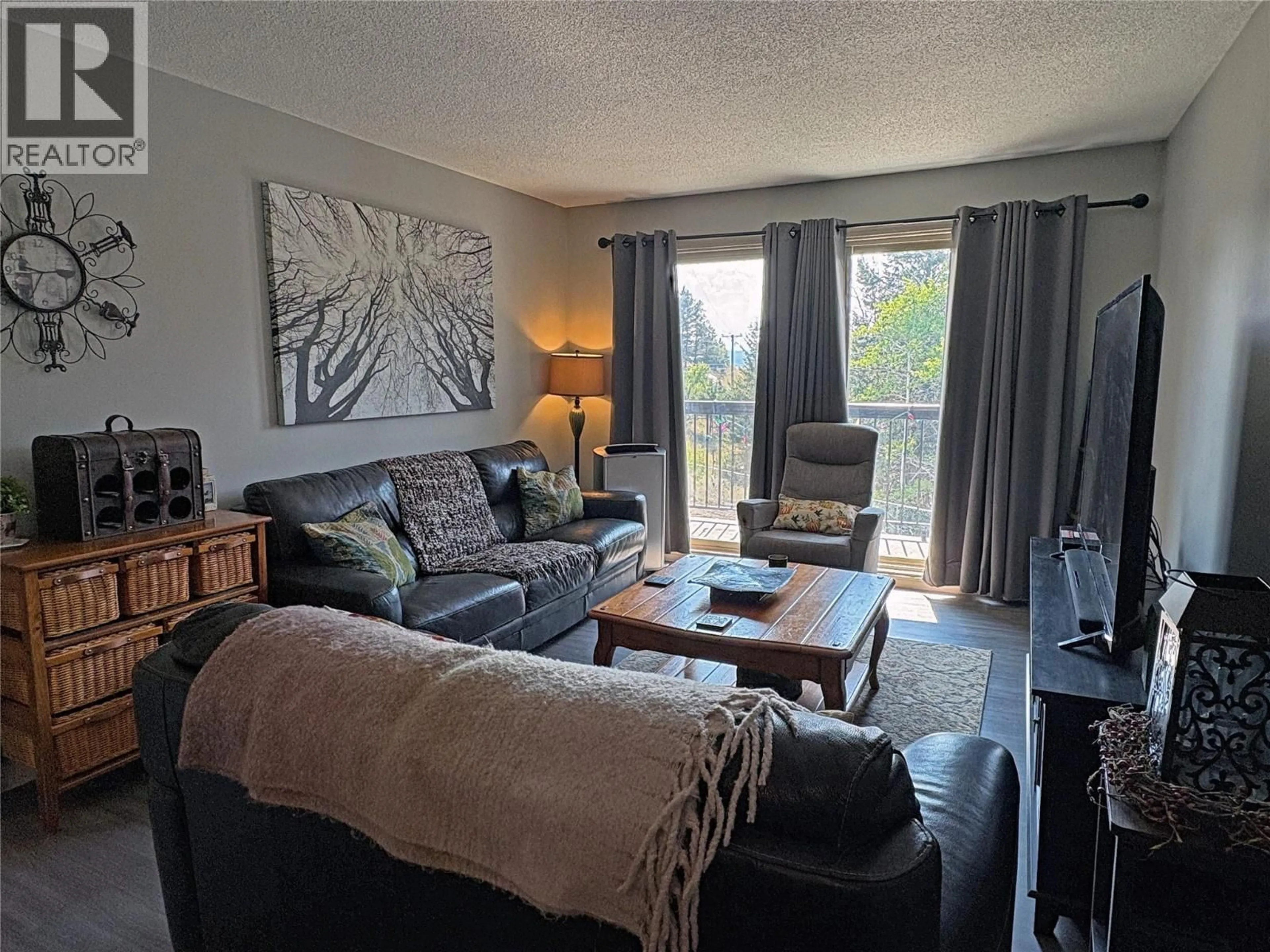 Living room with furniture, wood/laminate floor for 213 - 308 CHARTRAND AVENUE, Logan Lake British Columbia V0K1W0