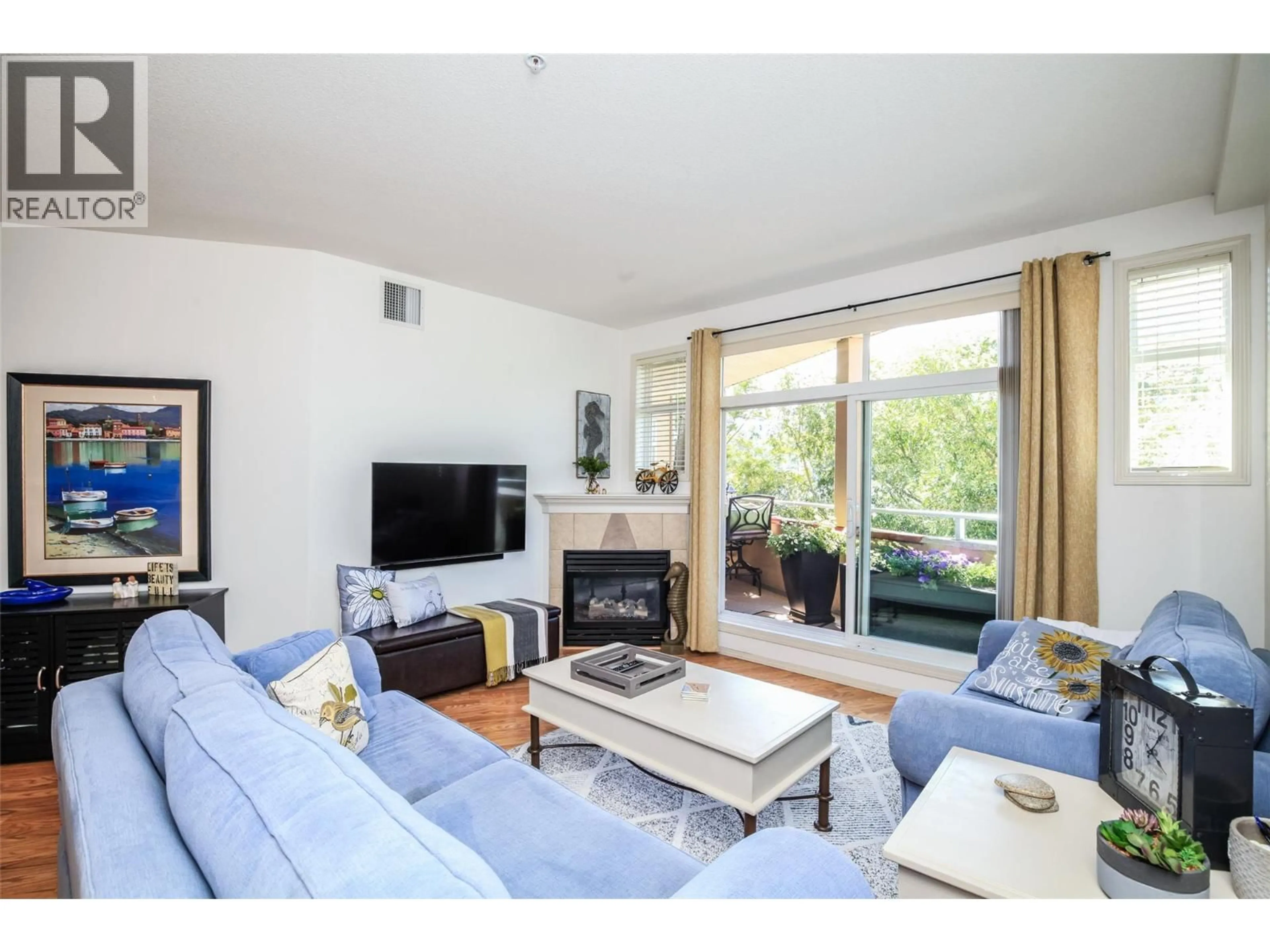 Living room with furniture, wood/laminate floor for 312 - 1088 SUNSET DRIVE, Kelowna British Columbia V1Y9W1