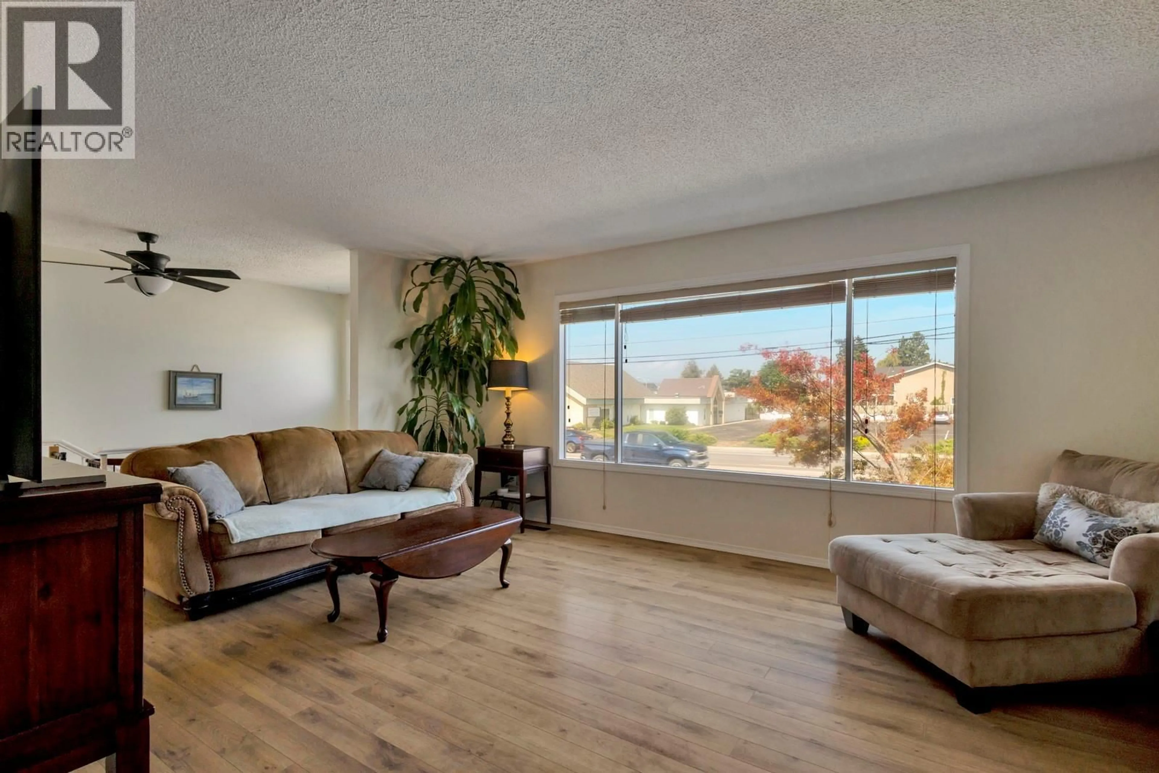 Living room with furniture, wood/laminate floor for 2917 SPRINGFIELD ROAD, Kelowna British Columbia V1X4N5
