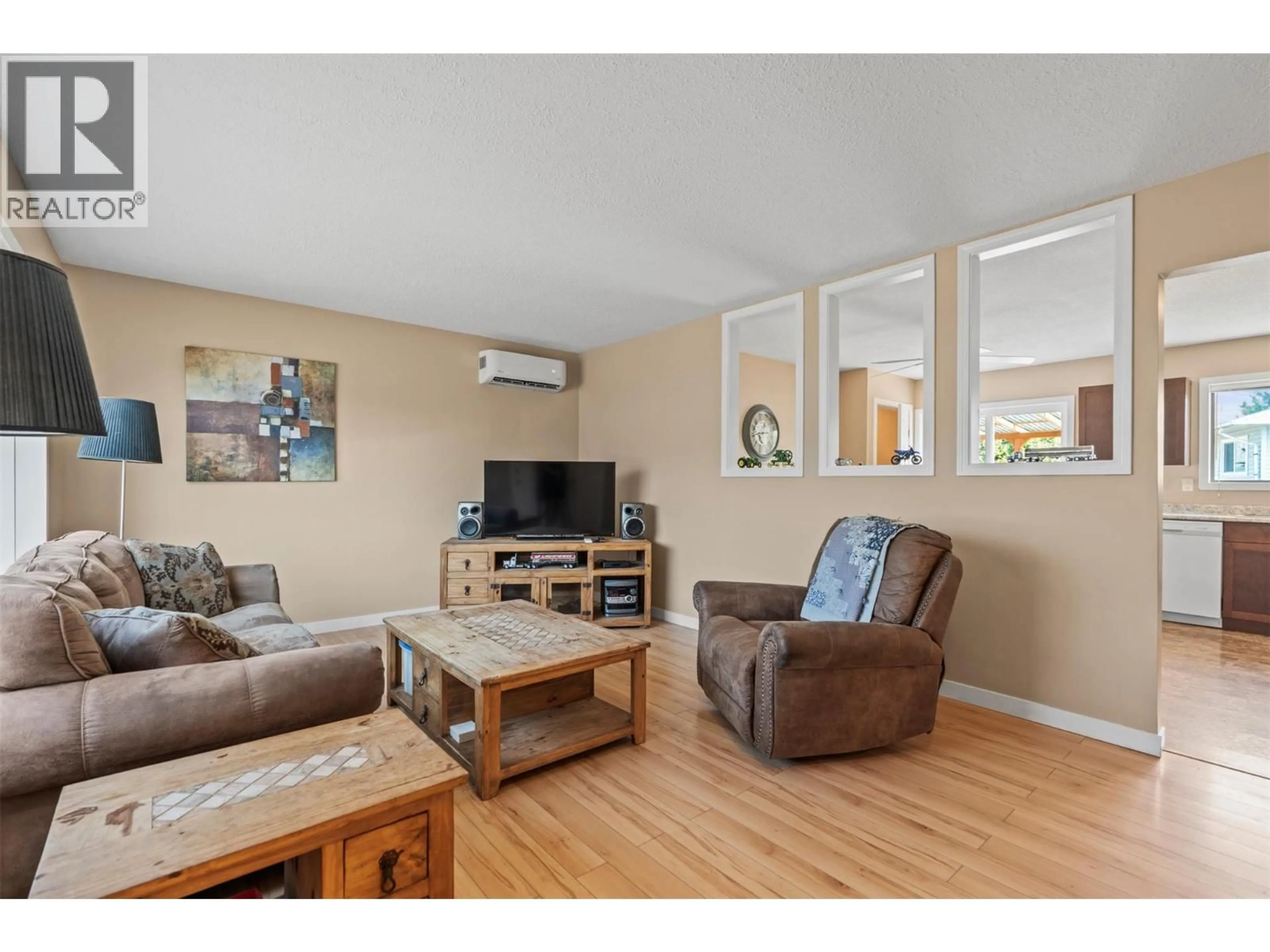 Living room with furniture, wood/laminate floor for 5609 WILLOW PLACE, Vernon British Columbia V1T8N9
