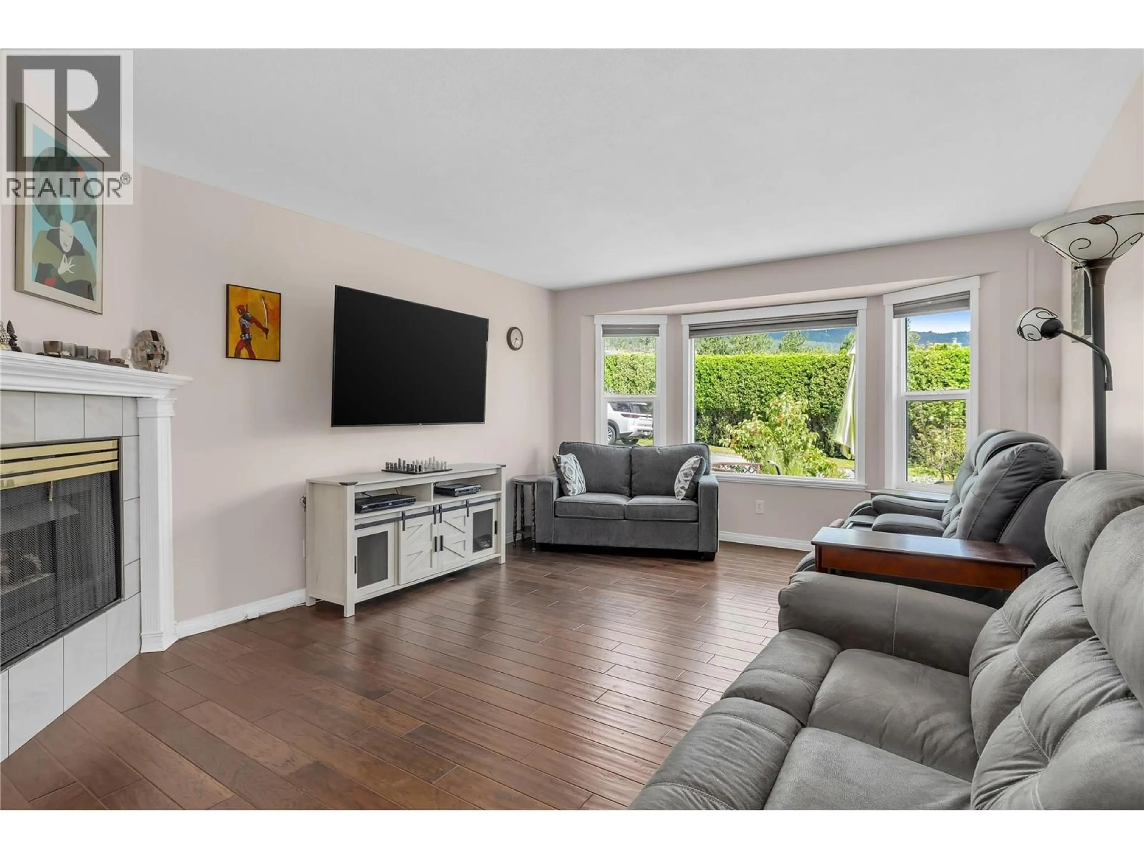 Living room with furniture, wood/laminate floor for 23 - 6400 SPENCER ROAD, Kelowna British Columbia V1V1R6