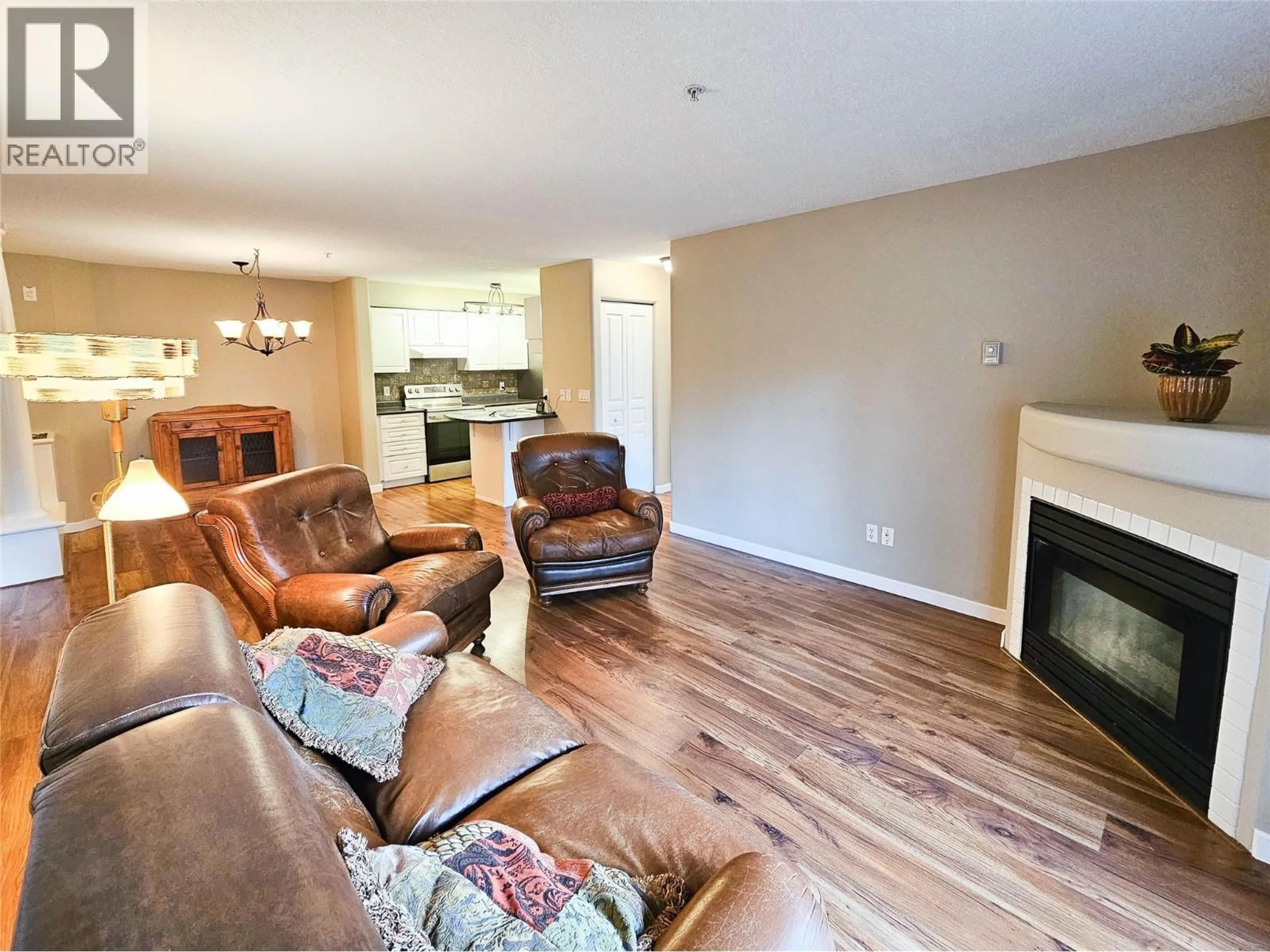 Living room with furniture, wood/laminate floor for 204 - 3221 CENTENNIAL DRIVE, Vernon British Columbia V1T2T8