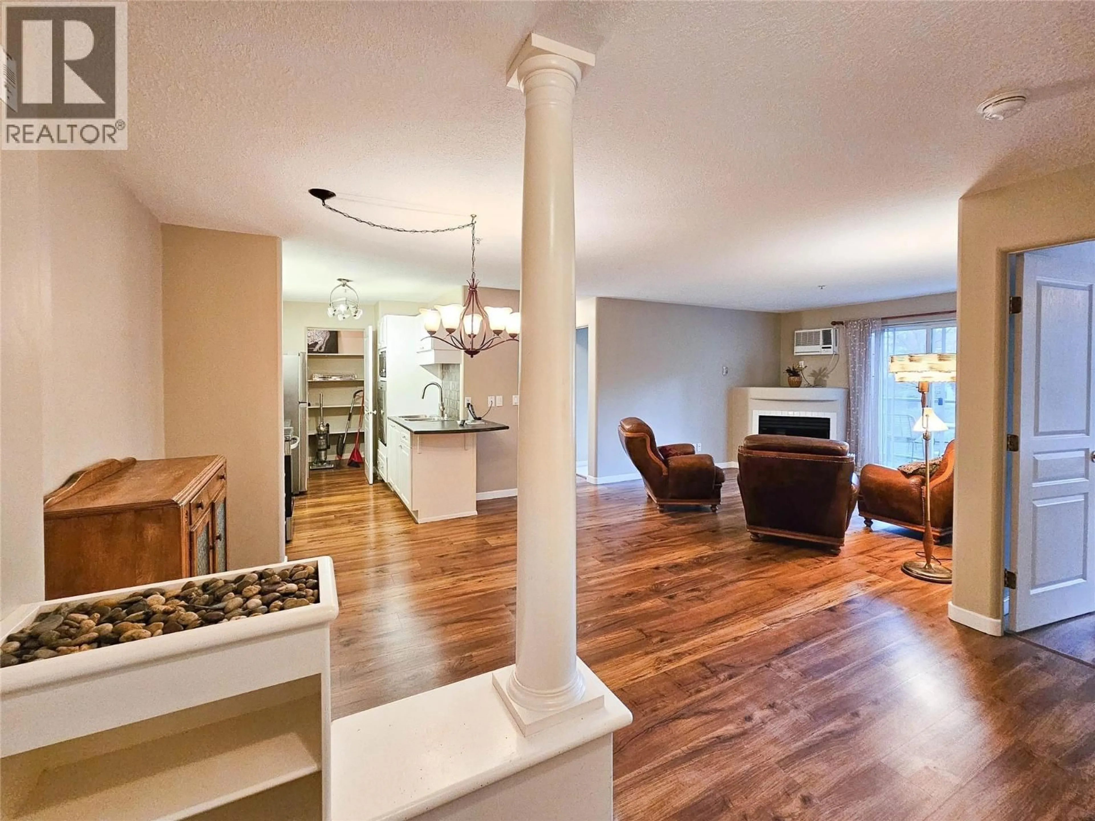 Living room with furniture, wood/laminate floor for 204 - 3221 CENTENNIAL DRIVE, Vernon British Columbia V1T2T8