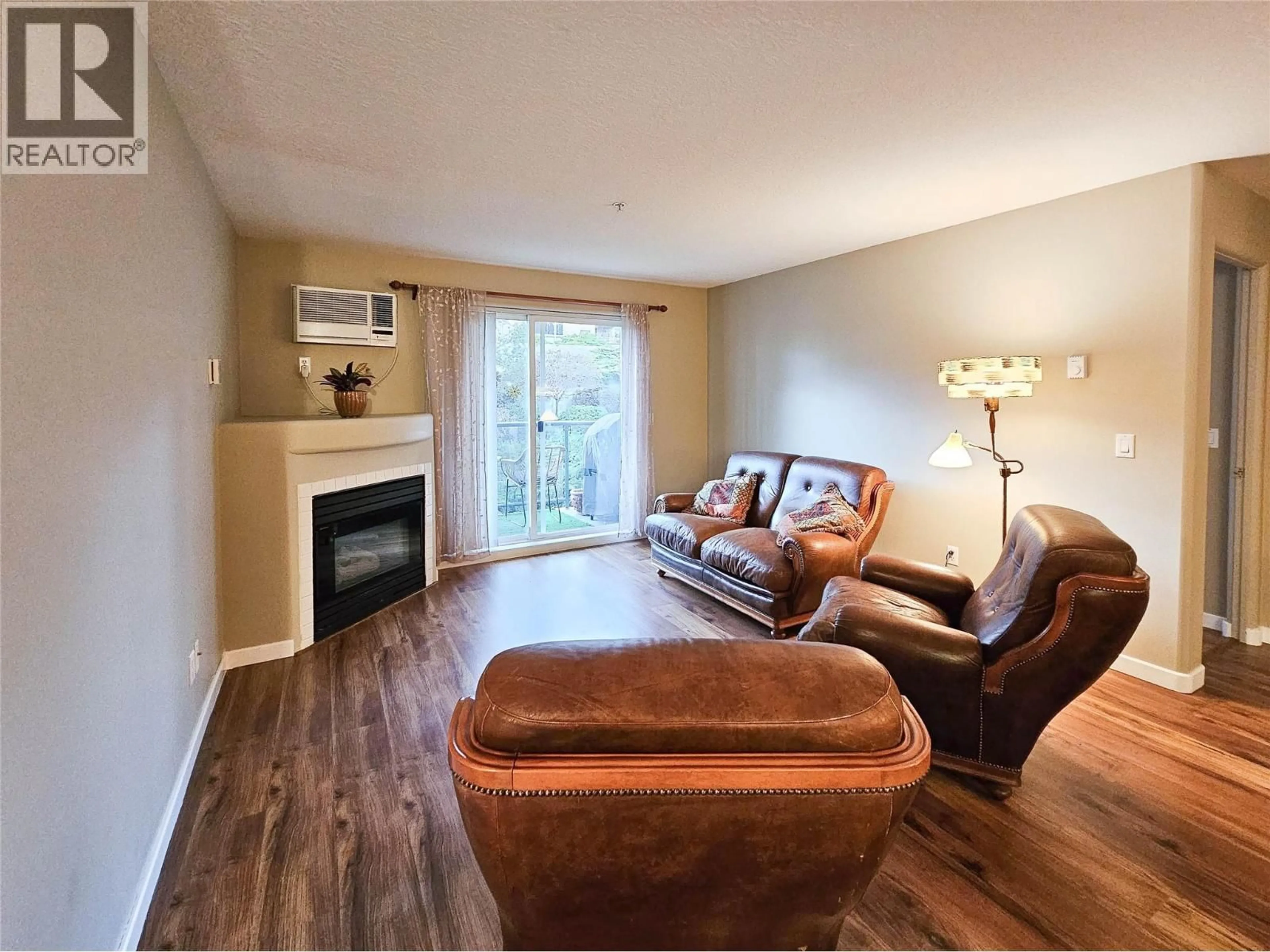Living room with furniture, wood/laminate floor for 204 - 3221 CENTENNIAL DRIVE, Vernon British Columbia V1T2T8