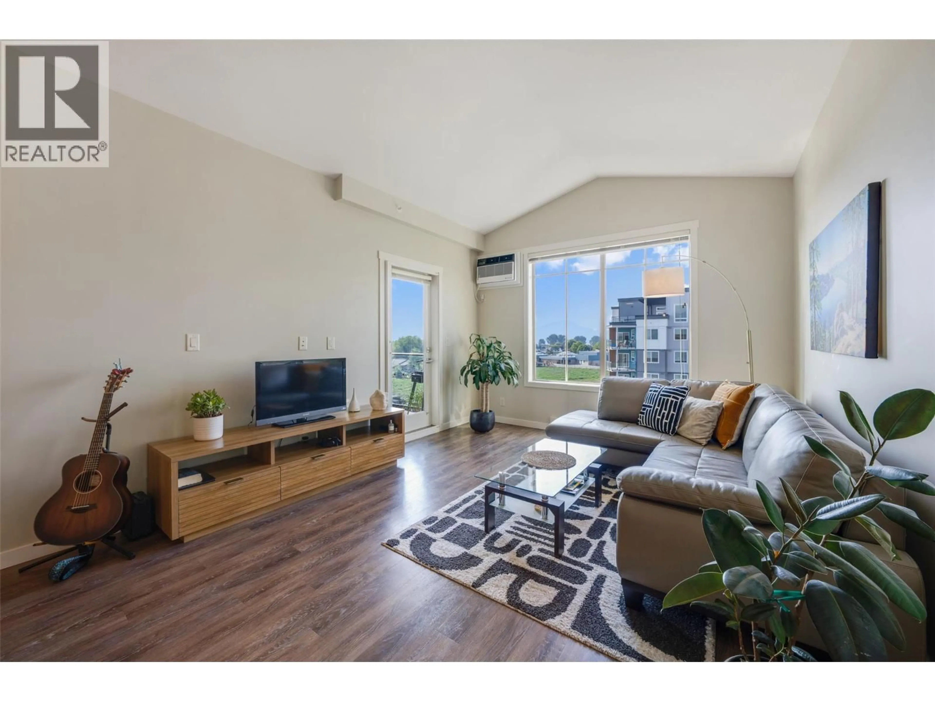 Living room with furniture, wood/laminate floor for 407 - 3733 CASORSO ROAD, Kelowna British Columbia V1W5E3