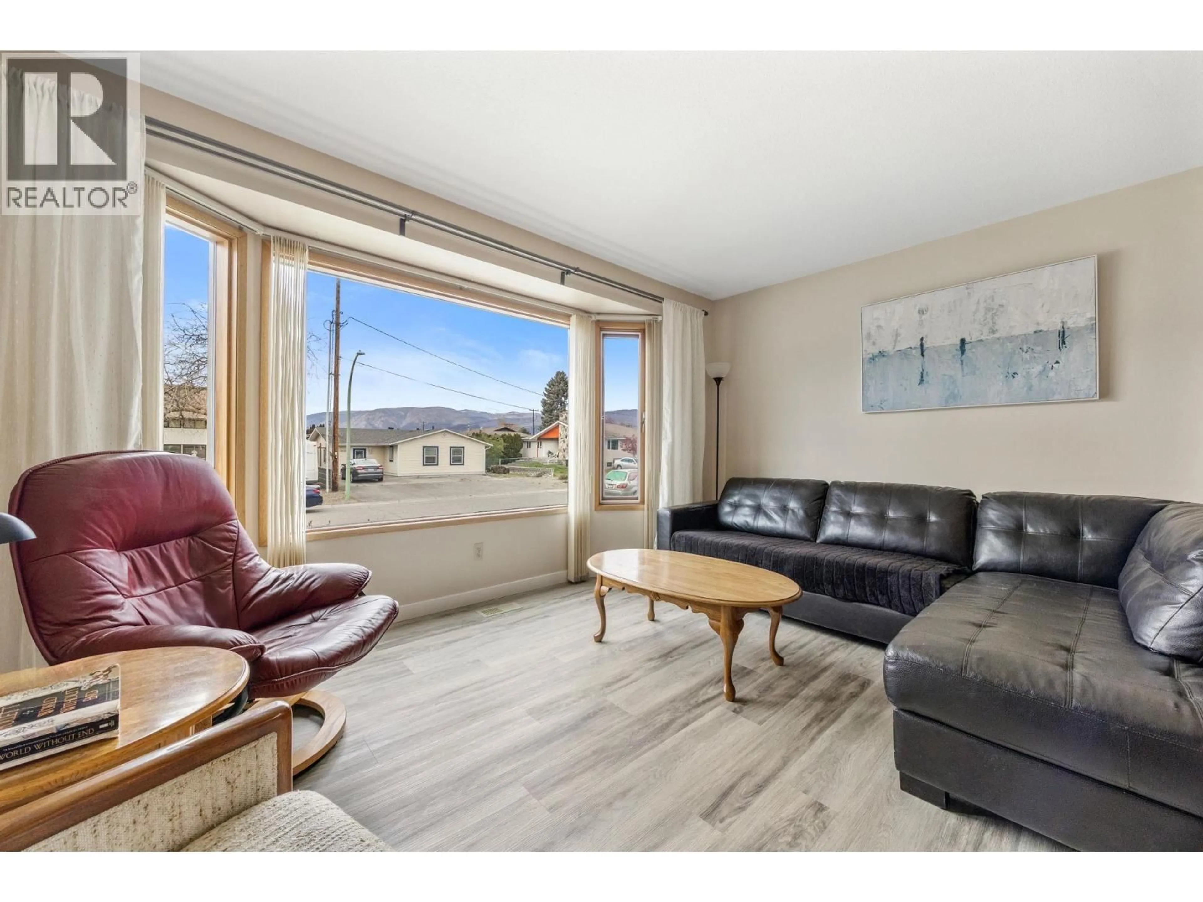 Living room with furniture, wood/laminate floor for 3445 BARBERRY STREET, Kelowna British Columbia V1W3V6