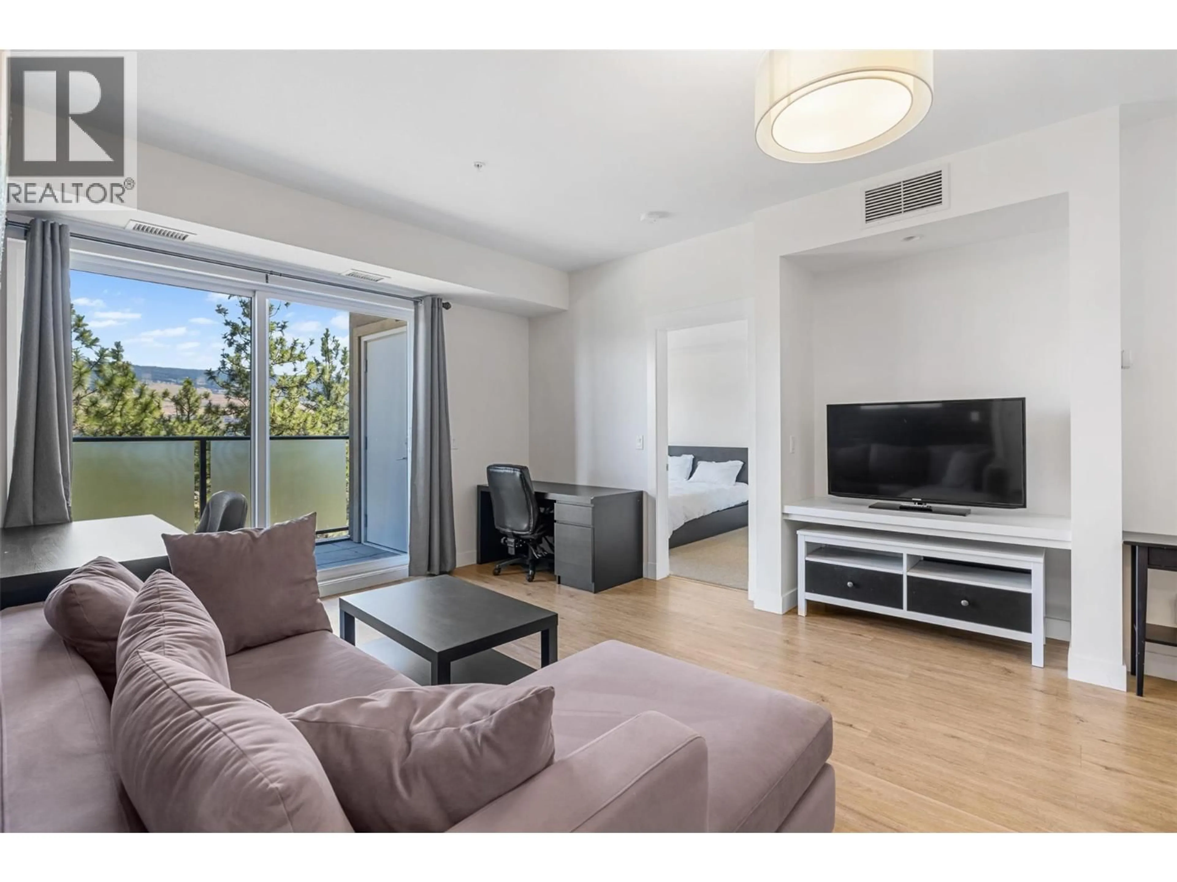 Living room with furniture, wood/laminate floor for 104 - 985 ACADEMY WAY, Kelowna British Columbia V1V3C8