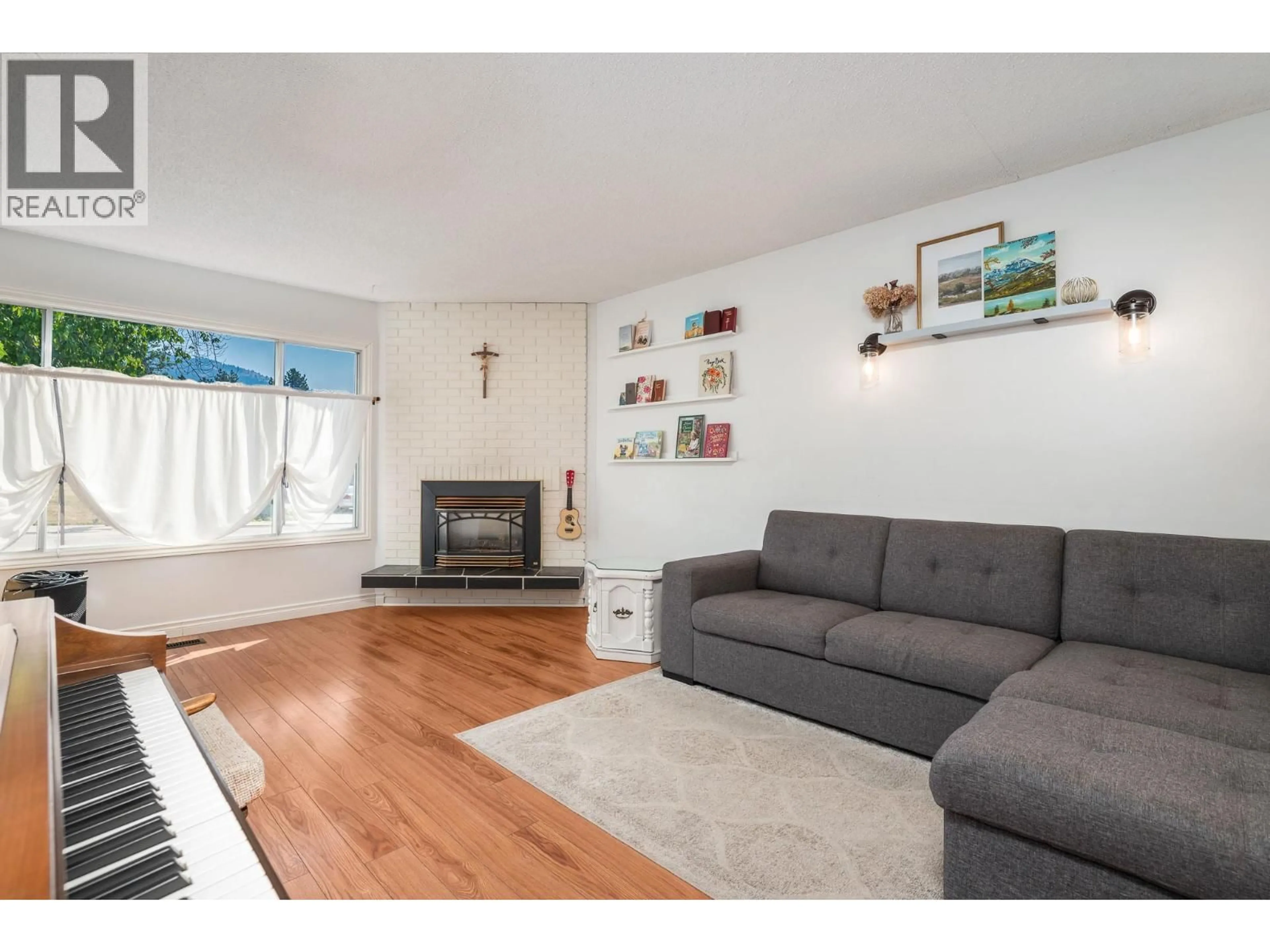 Living room with furniture, wood/laminate floor for 2506 14 STREET, Vernon British Columbia V1T7H7