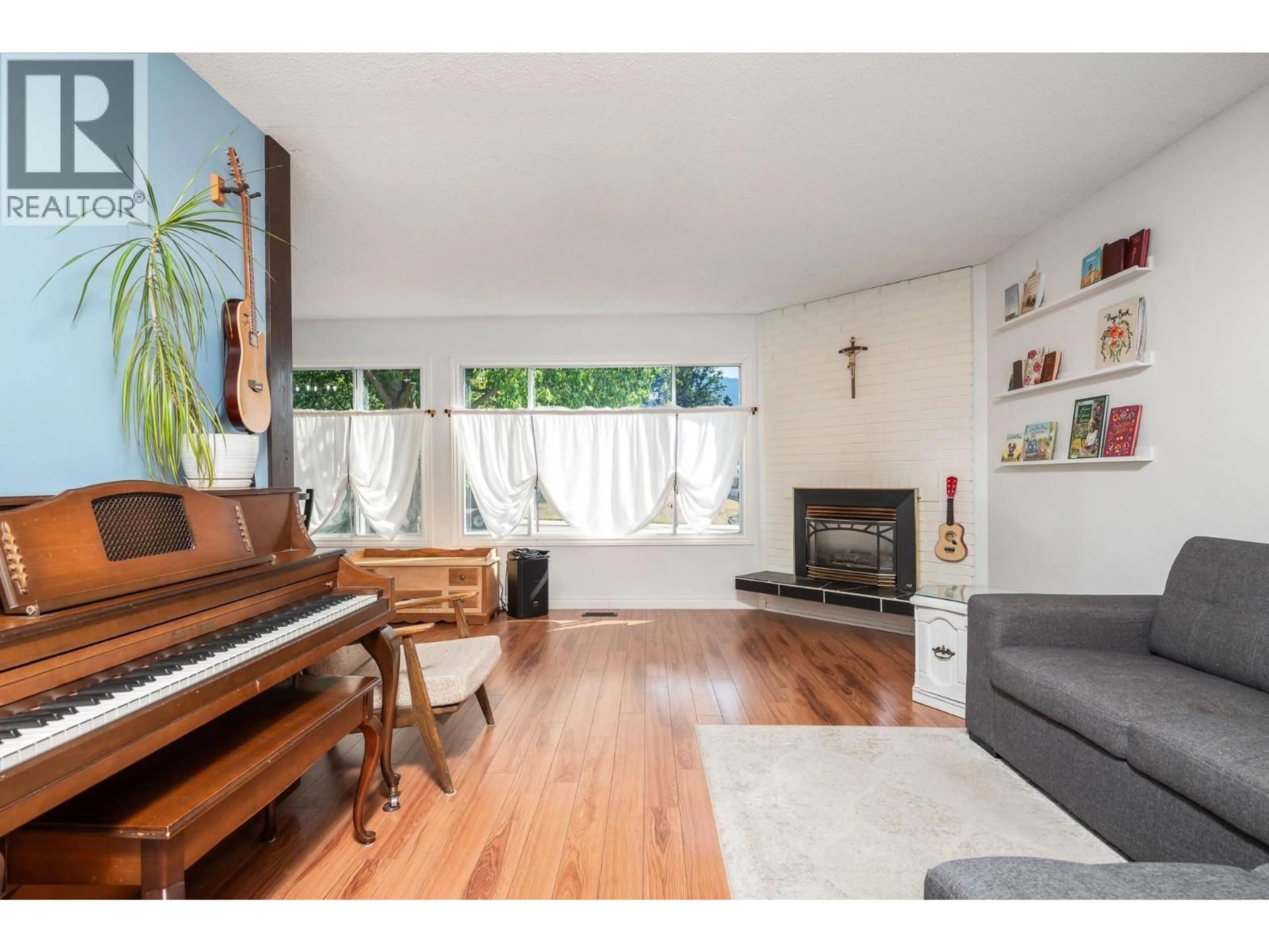 Living room with furniture, wood/laminate floor for 2506 14 STREET, Vernon British Columbia V1T7H7