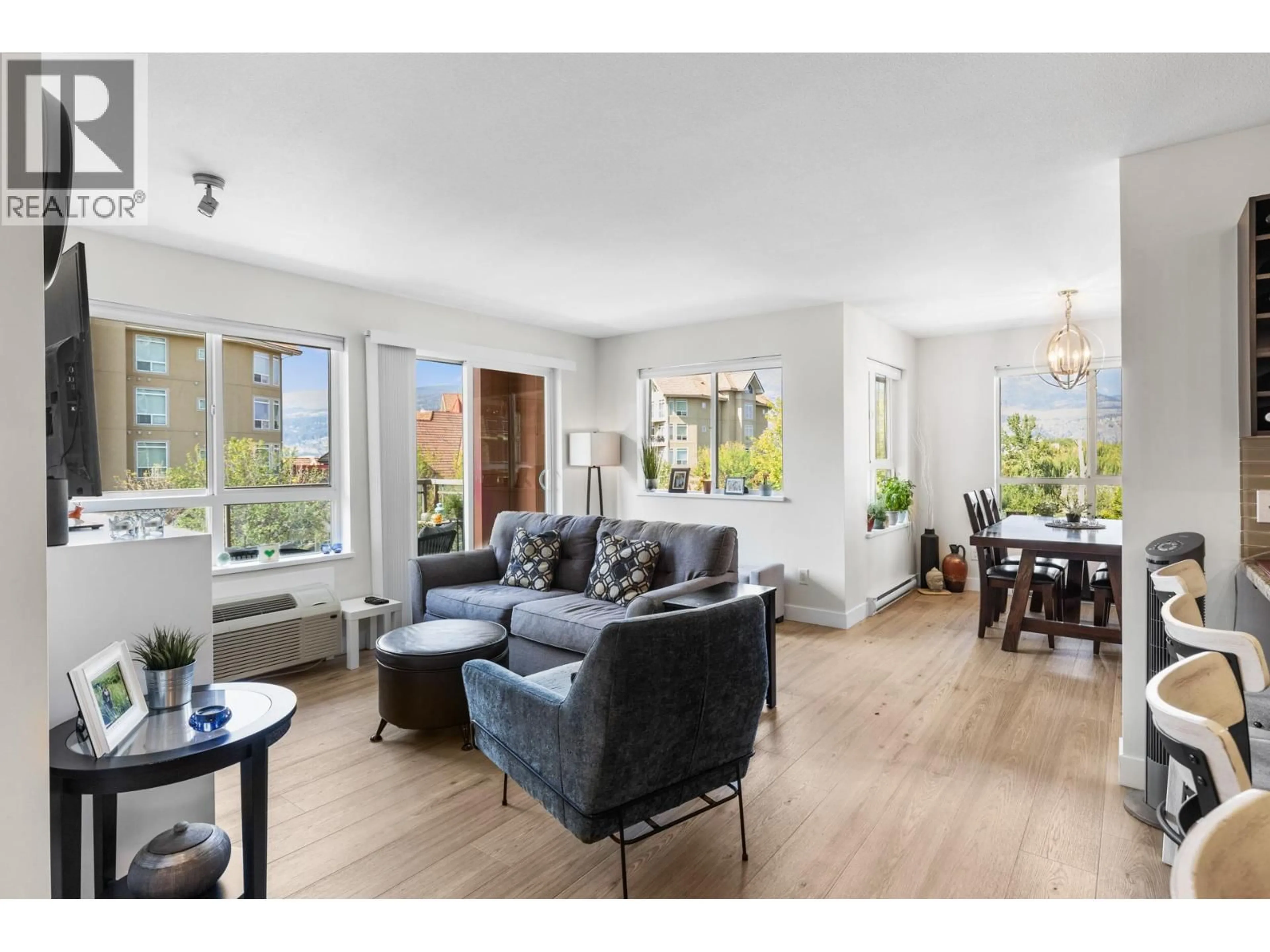 Living room with furniture, wood/laminate floor for 406 - 1083 SUNSET DRIVE, Kelowna British Columbia V1Y9Z2