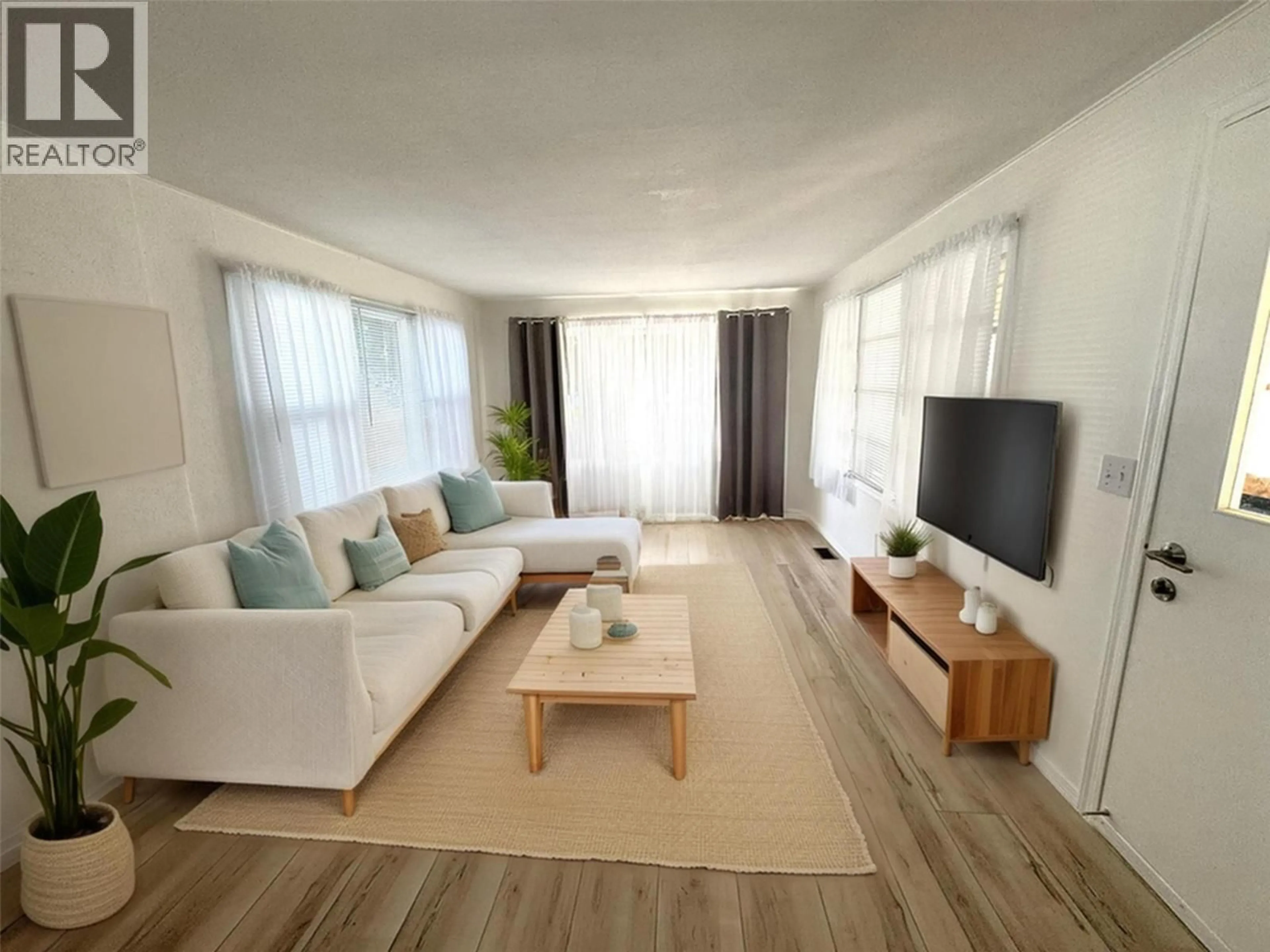 Living room with furniture, wood/laminate floor for E8 - 4505 MCLEAN CREEK ROAD, Okanagan Falls British Columbia V0H1R1