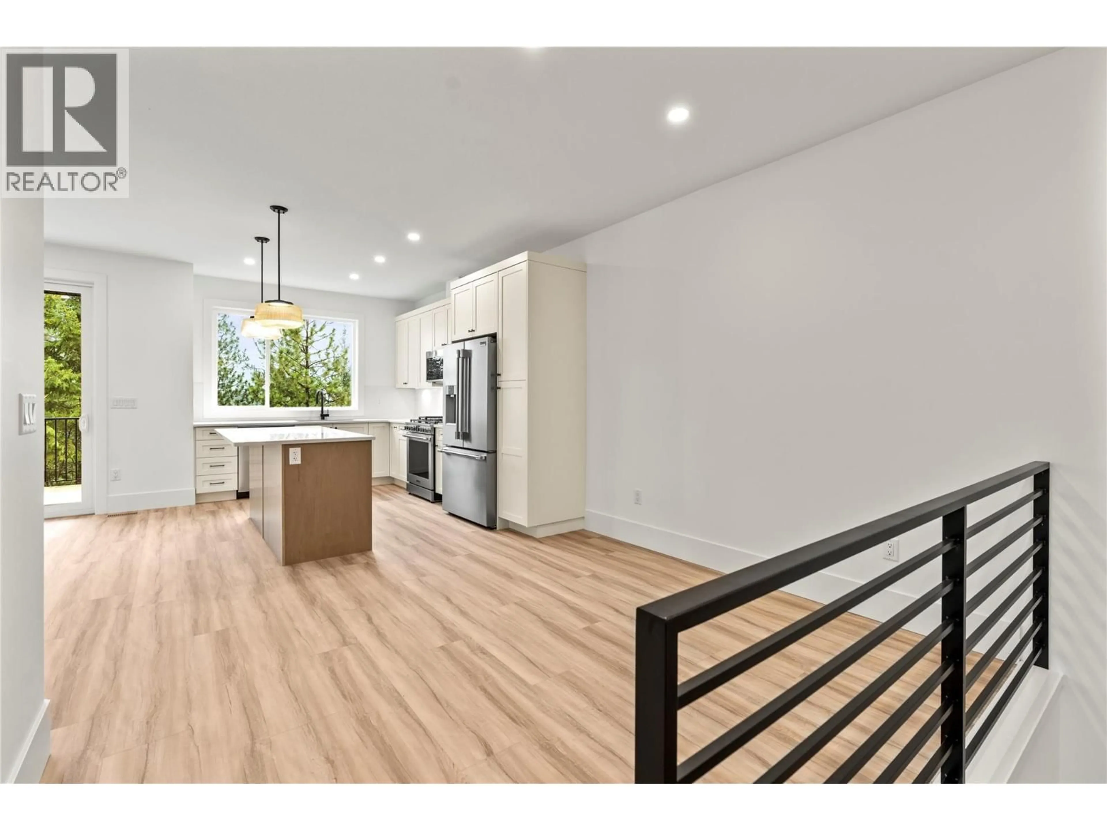 Open concept kitchen, wood/laminate floor for 7028 MANNING PLACE, Vernon British Columbia V1B0B6