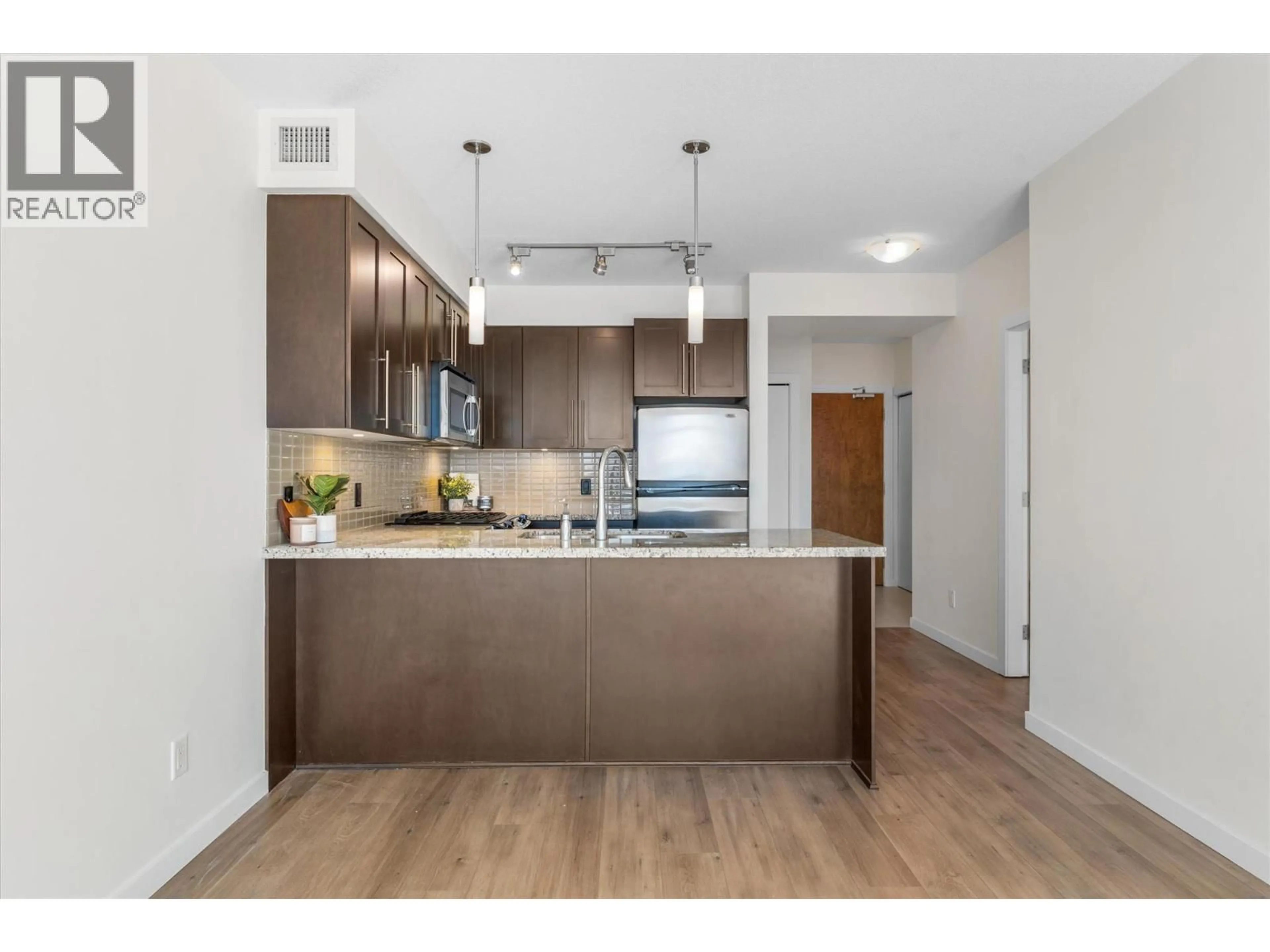 Open concept kitchen, wood/laminate floor for 1404 - 1075 SUNSET DRIVE, Kelowna British Columbia V1Y9Y9
