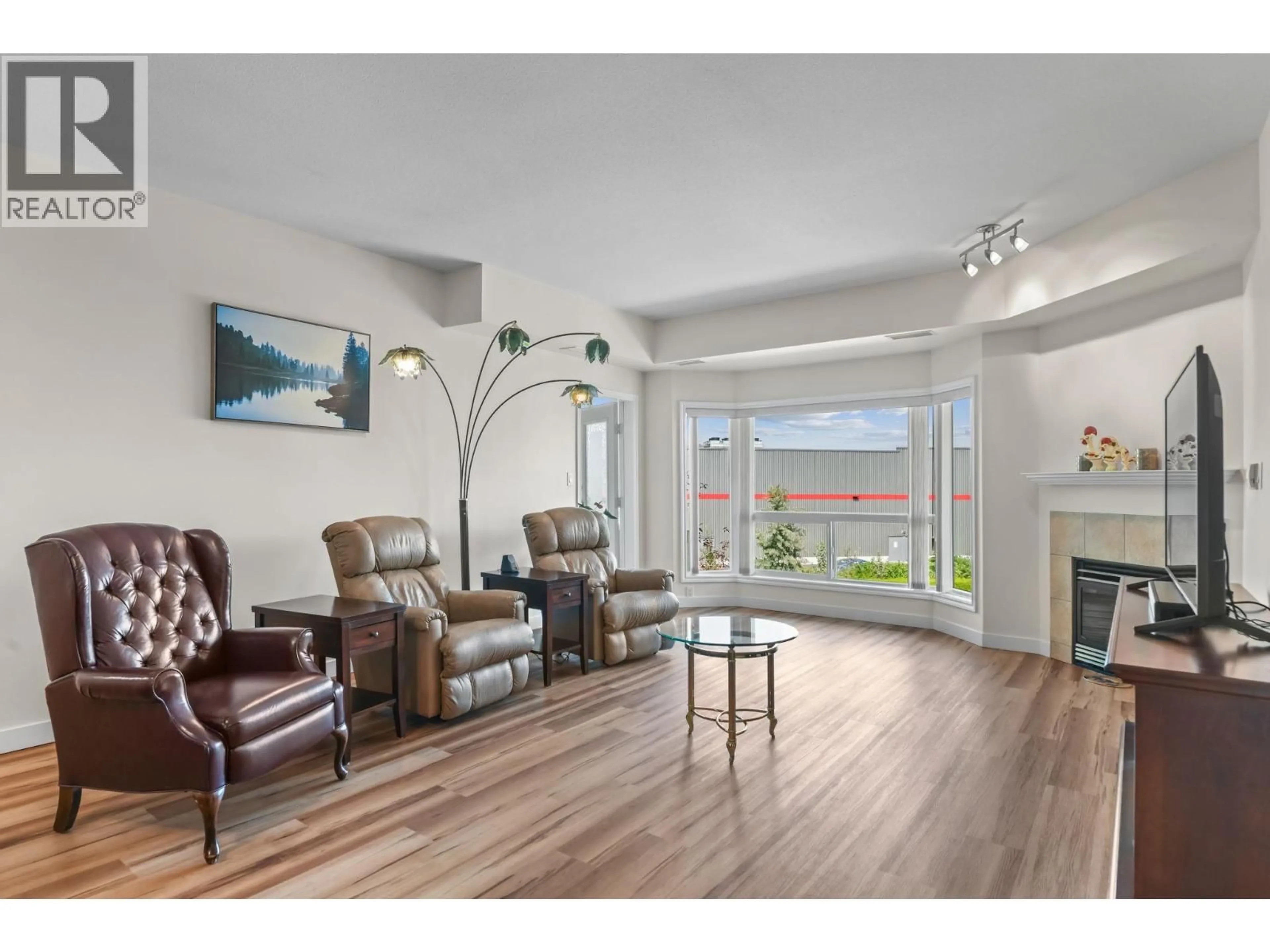Living room with furniture, wood/laminate floor for 303 - 1963 DURNIN ROAD, Kelowna British Columbia V1X7Y4