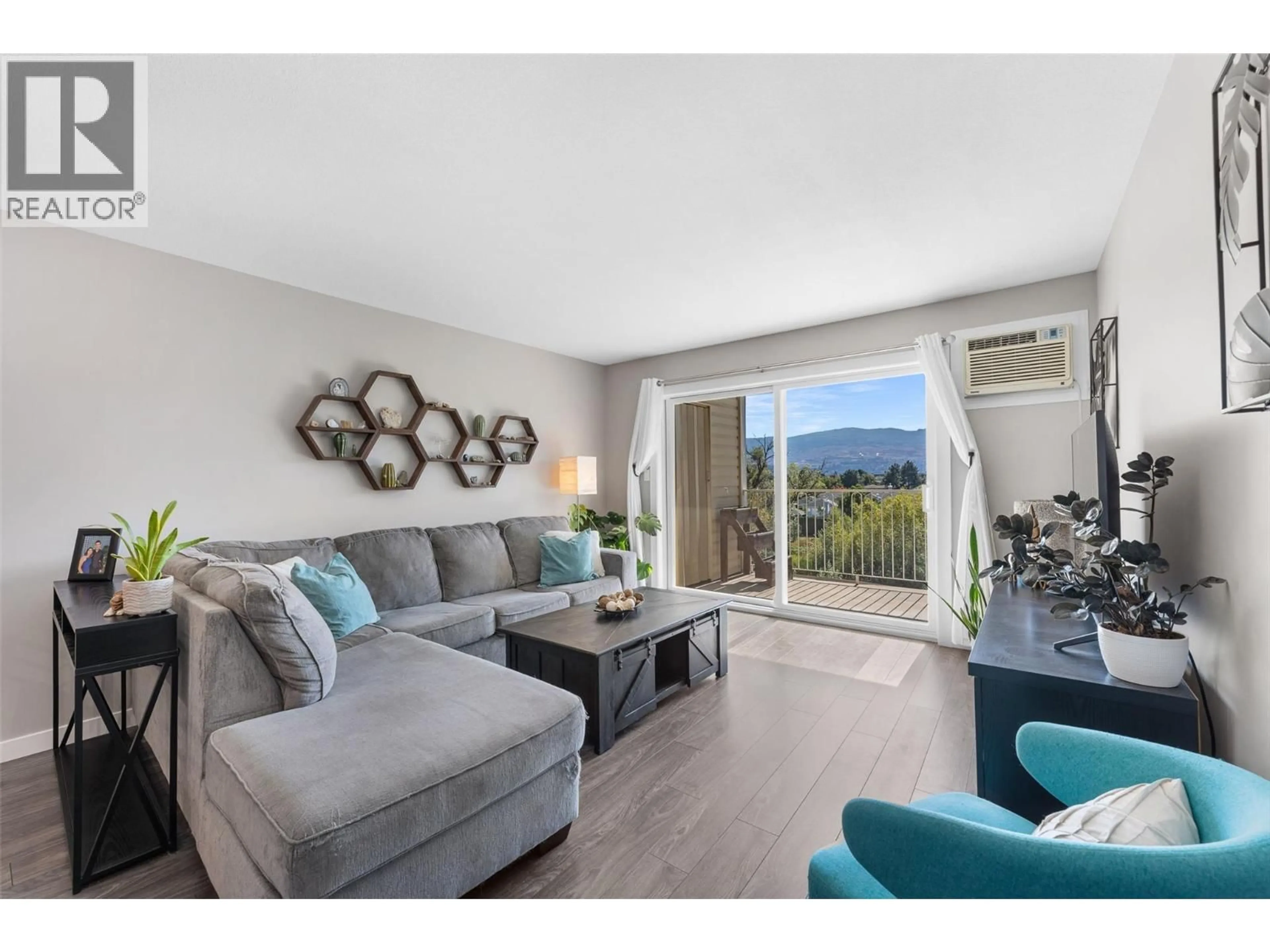 Living room with furniture, wood/laminate floor for 413 - 3163 RICHTER STREET, Kelowna British Columbia V1W3R4