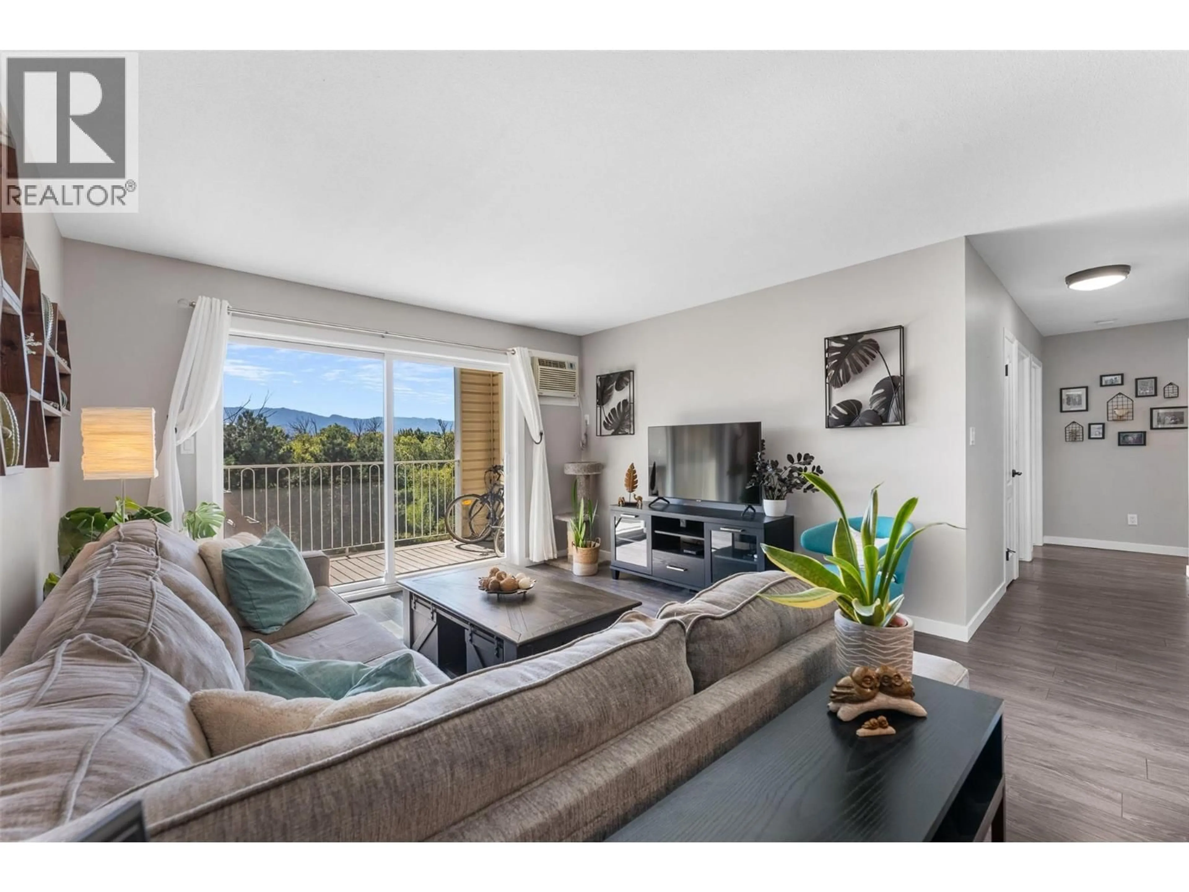 Living room with furniture, wood/laminate floor for 413 - 3163 RICHTER STREET, Kelowna British Columbia V1W3R4
