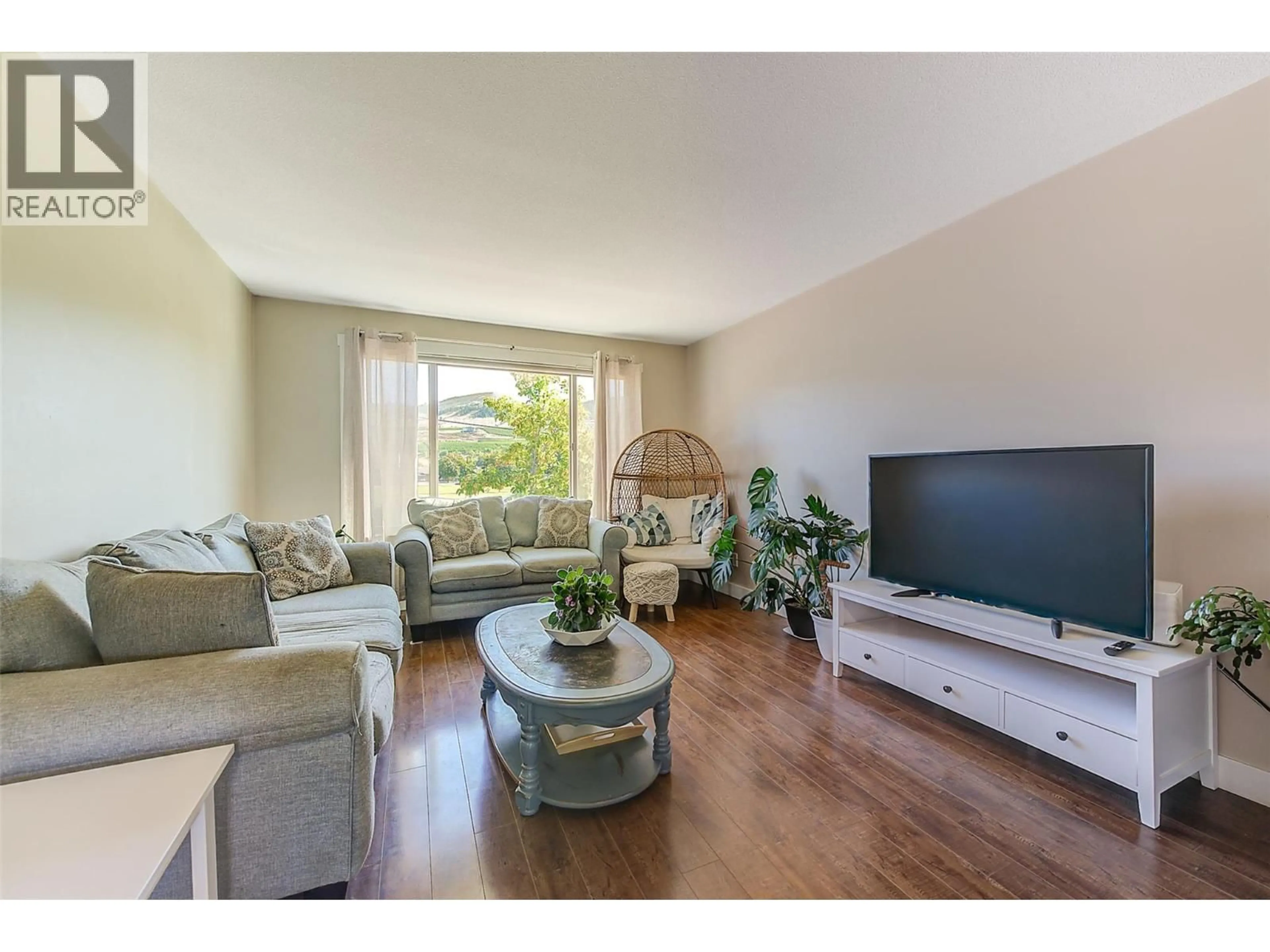 Living room with furniture, wood/laminate floor for 244 PRIOR ROAD SOUTH, Kelowna British Columbia V1X1W2