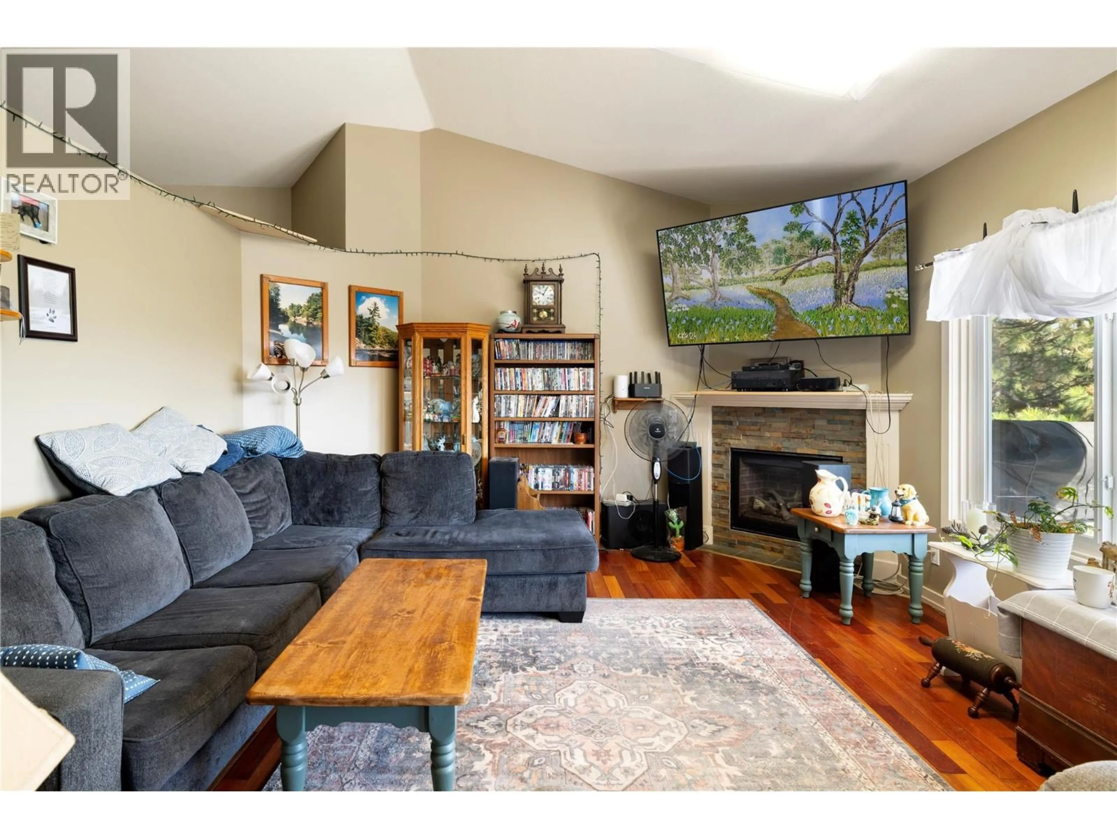 Living room with furniture, wood/laminate floor for 2391 NAHANNI COURT, Kelowna British Columbia V1V1N1