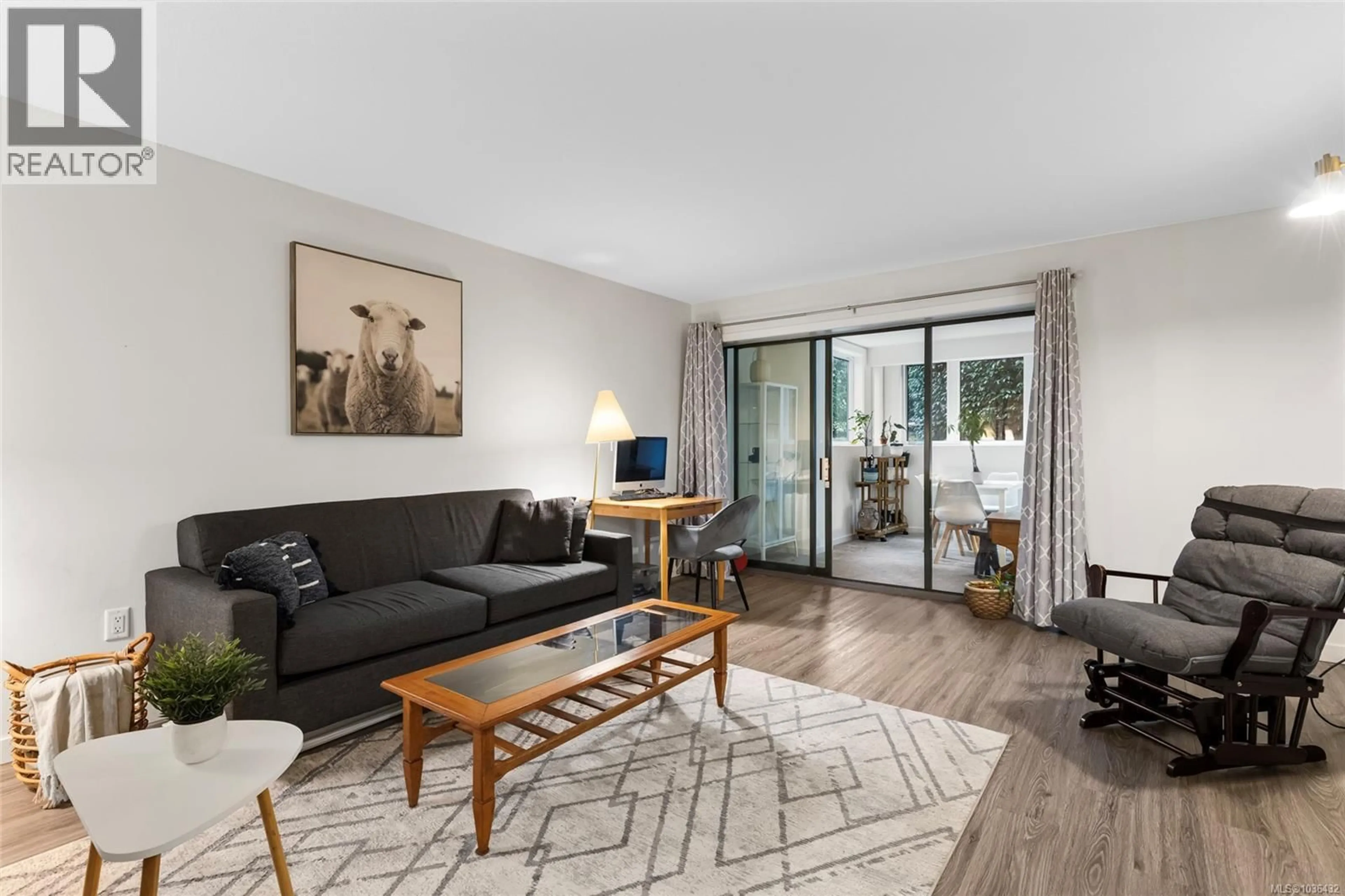 Living room with furniture, wood/laminate floor for 103 - 1875 LANSDOWNE ROAD, Saanich British Columbia V8P1A9