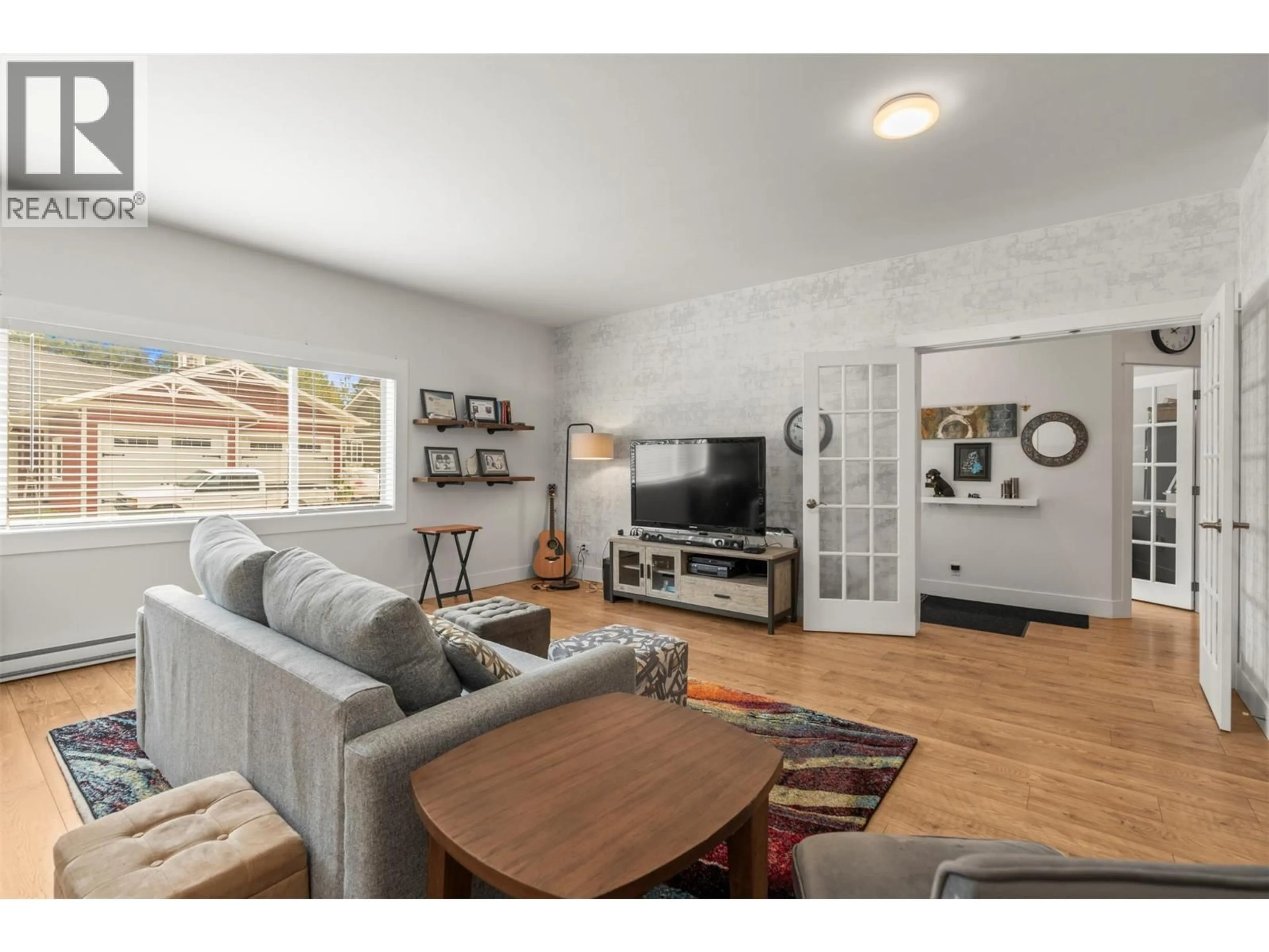 Living room with furniture, wood/laminate floor for 205 FALCON AVENUE, Vernon British Columbia V1H2A1