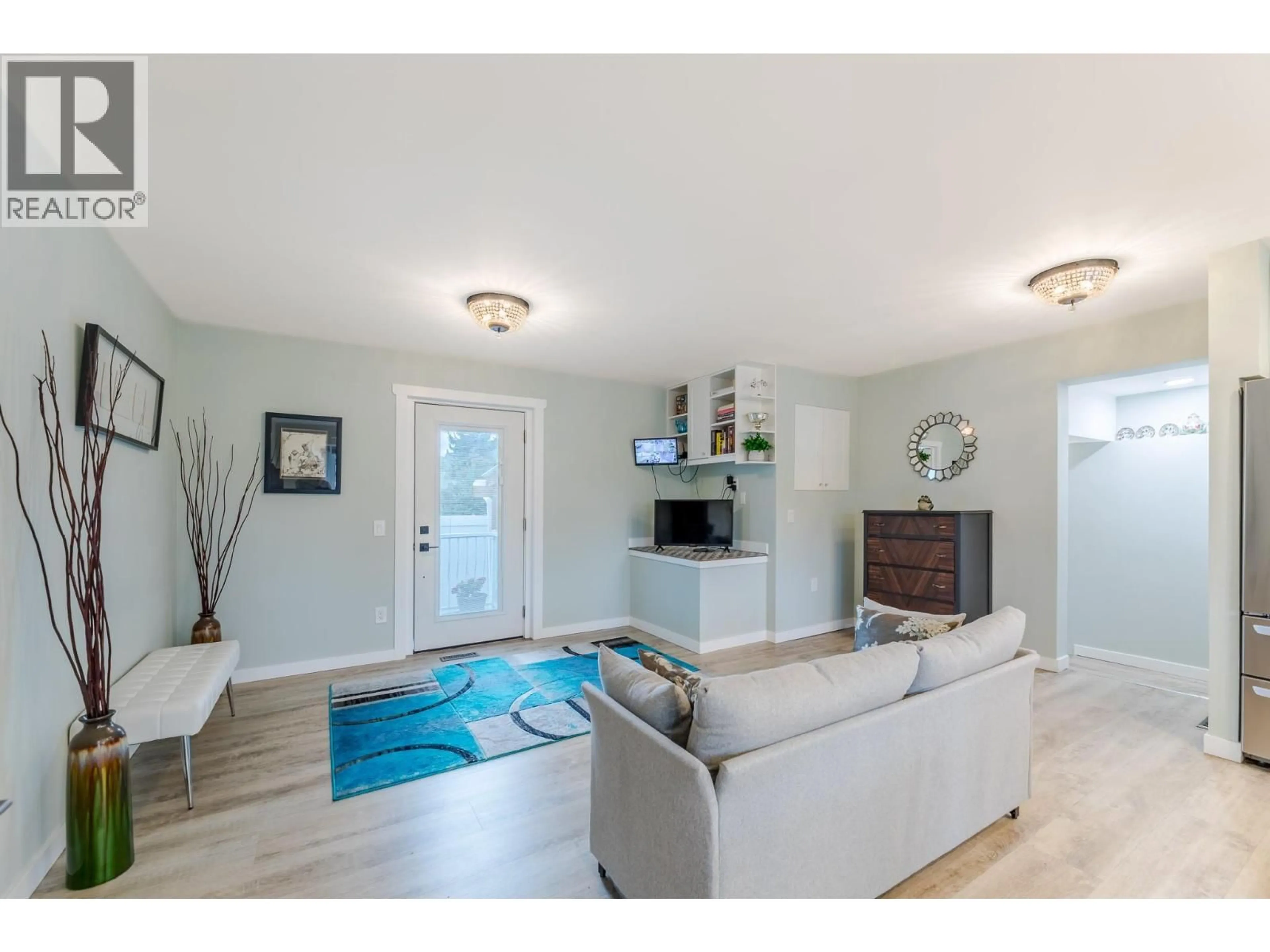 Living room with furniture, wood/laminate floor for 10105 PRAIRIE VALLEY ROAD, Summerland British Columbia V0H1Z2