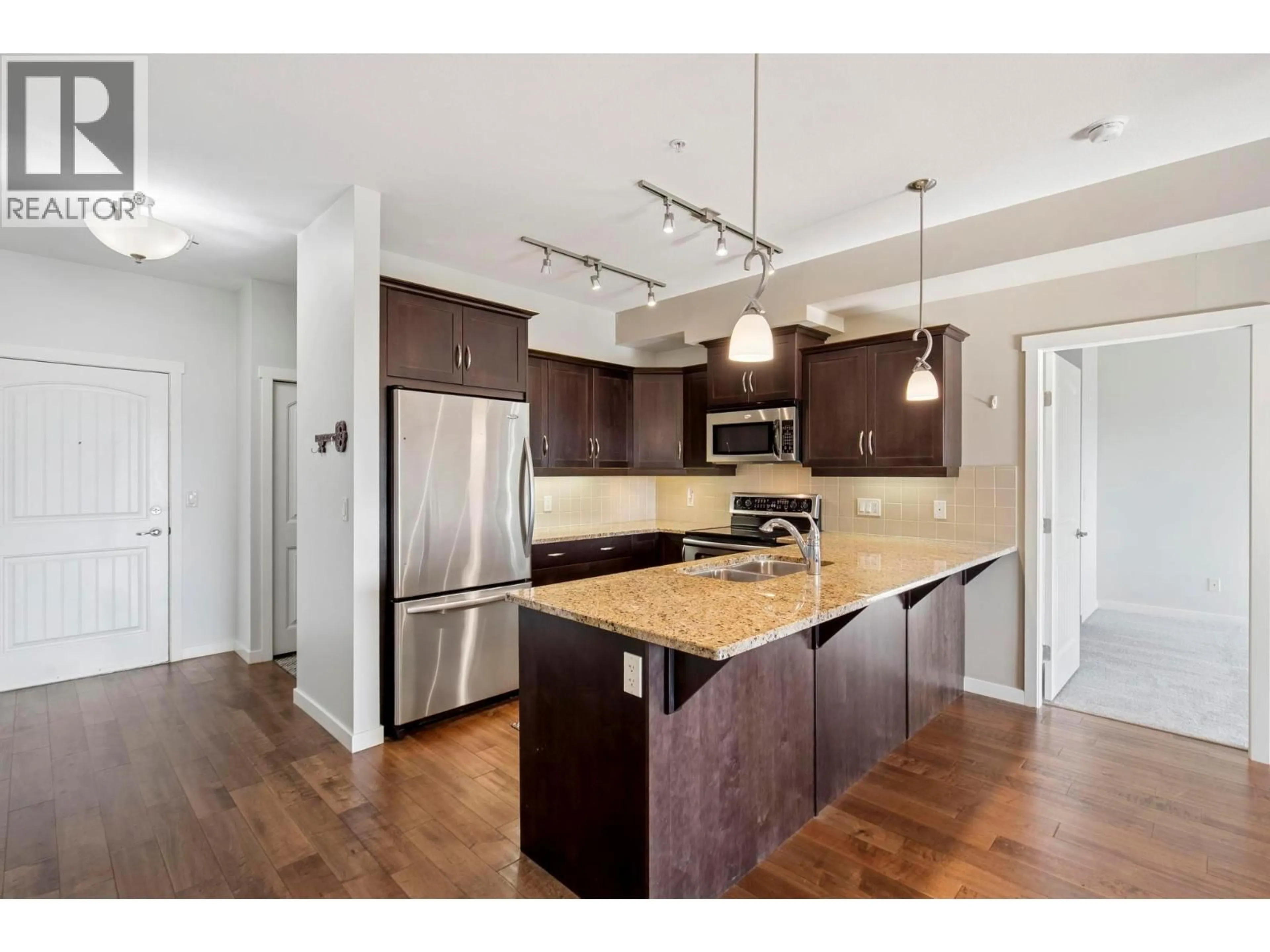 Open concept kitchen, wood/laminate floor for 205 - 3735 CASORSO ROAD, Kelowna British Columbia V1W5G1