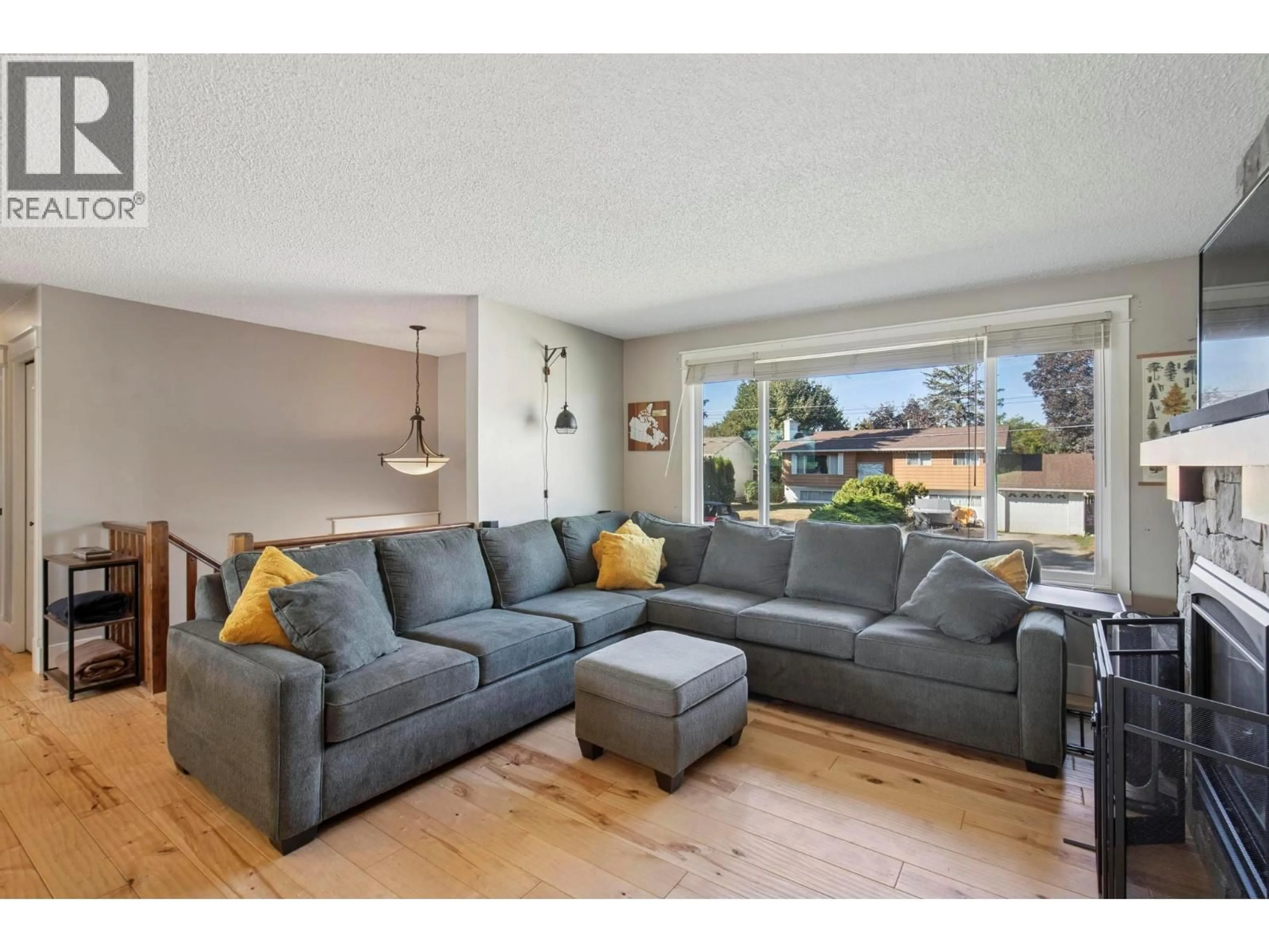 Living room with furniture, wood/laminate floor for 7901 GILES DRIVE, Coldstream British Columbia V1B1G6