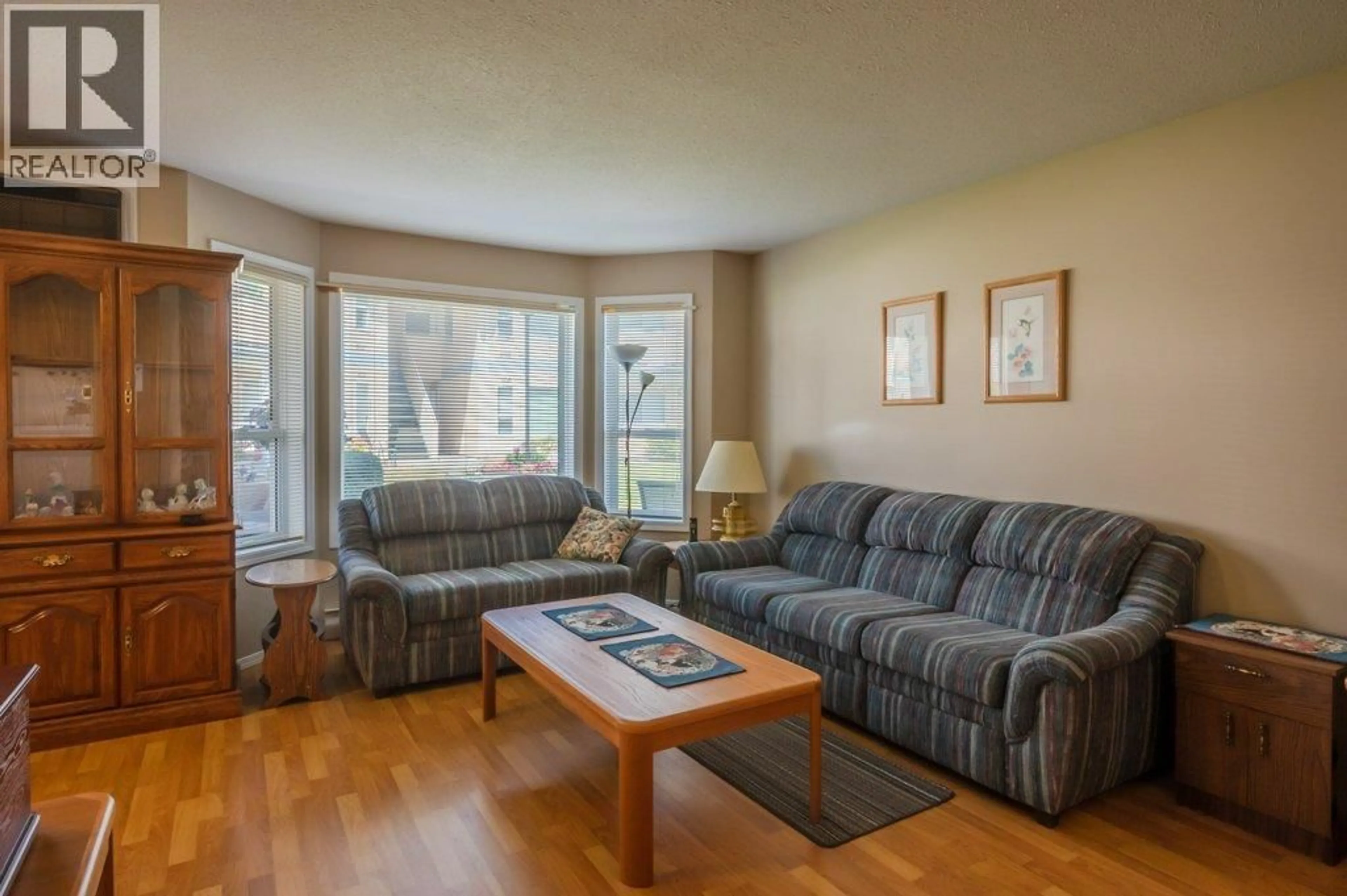 Living room with furniture, wood/laminate floor for 103 - 13014 ARMSTRONG AVENUE, Summerland British Columbia V0H1Z0
