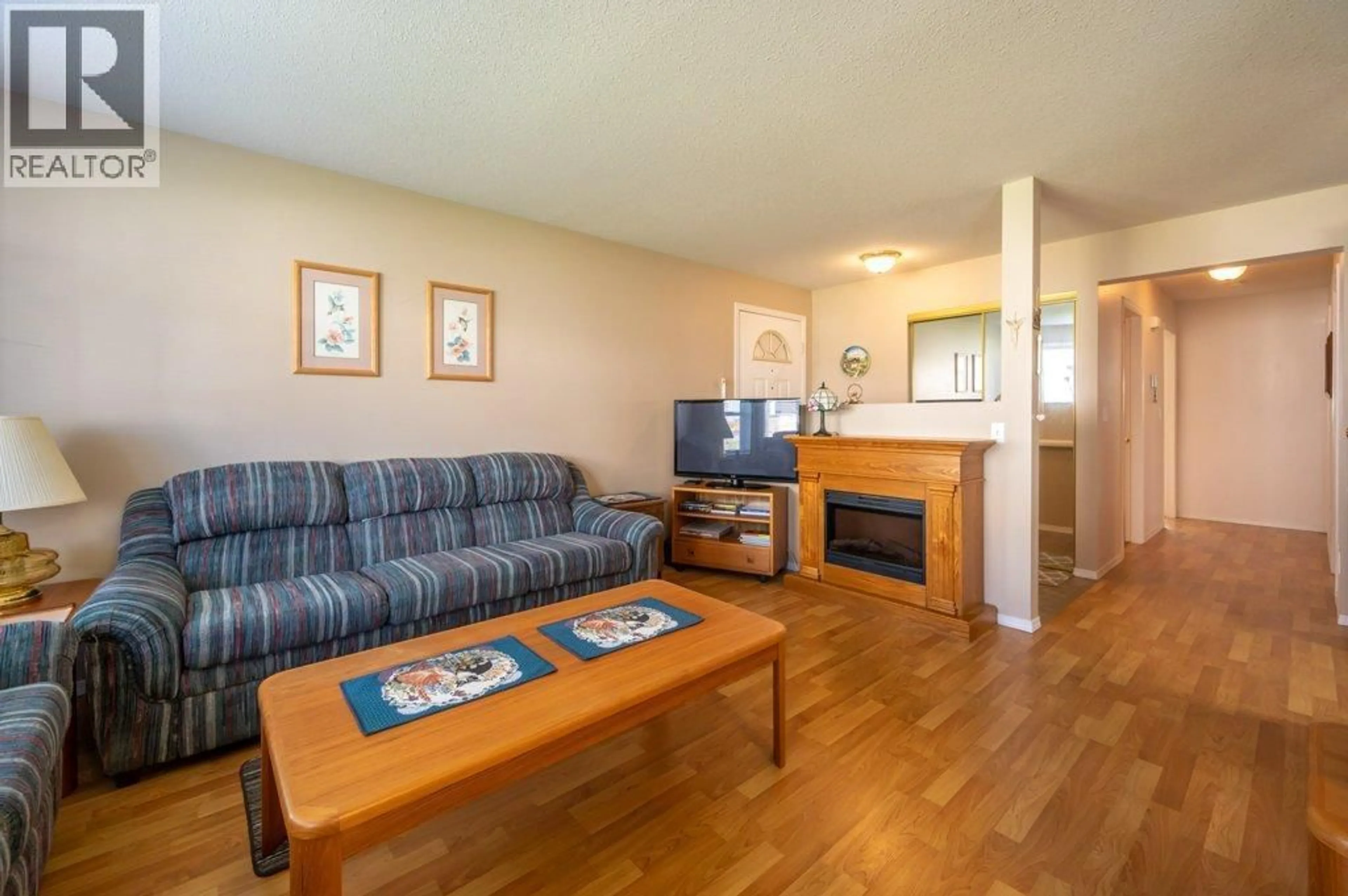 Living room with furniture, wood/laminate floor for 103 - 13014 ARMSTRONG AVENUE, Summerland British Columbia V0H1Z0