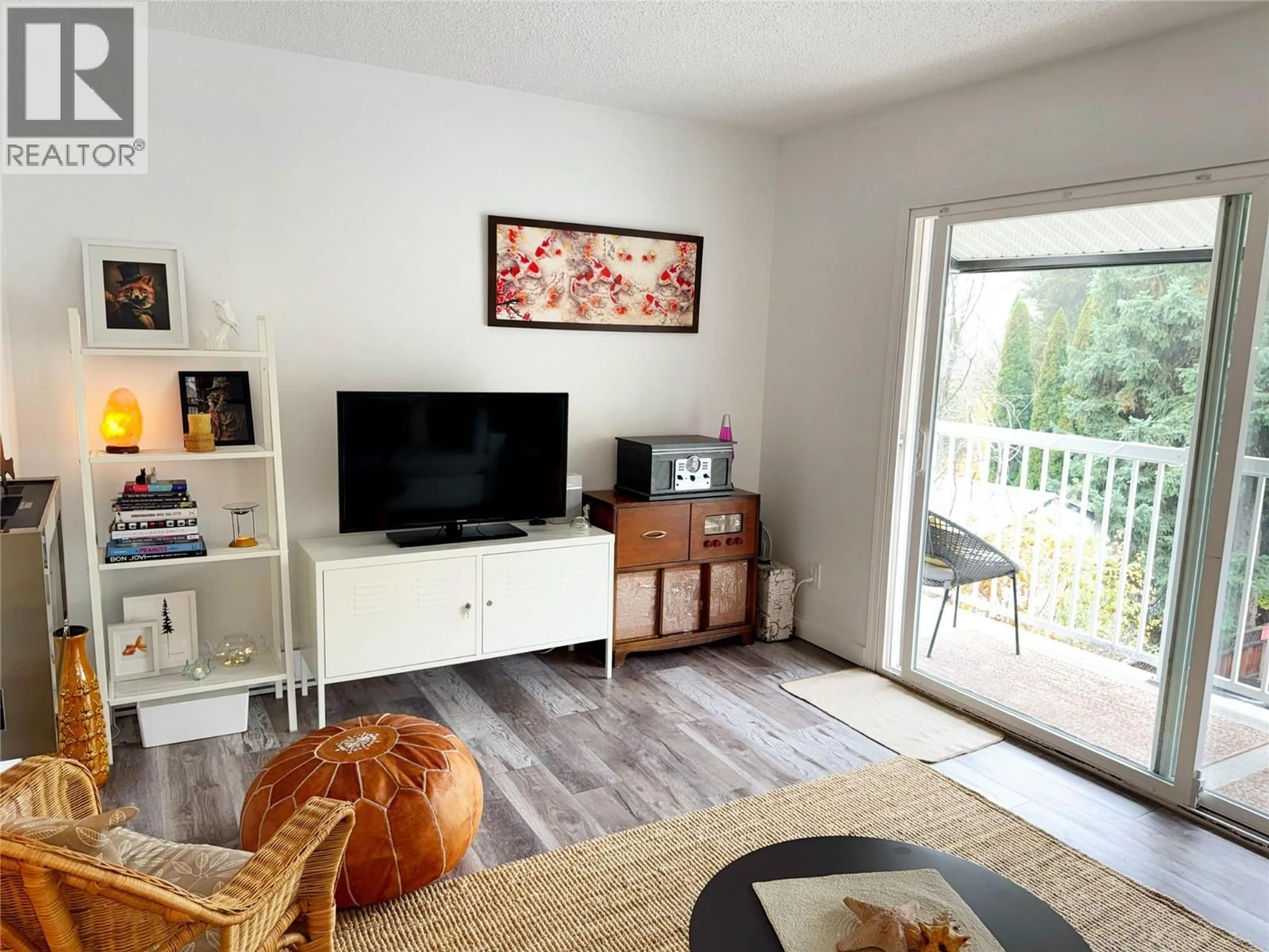Living room with furniture, wood/laminate floor for 304 - 880 WORDSWORTH AVENUE, Warfield British Columbia V1R2E9