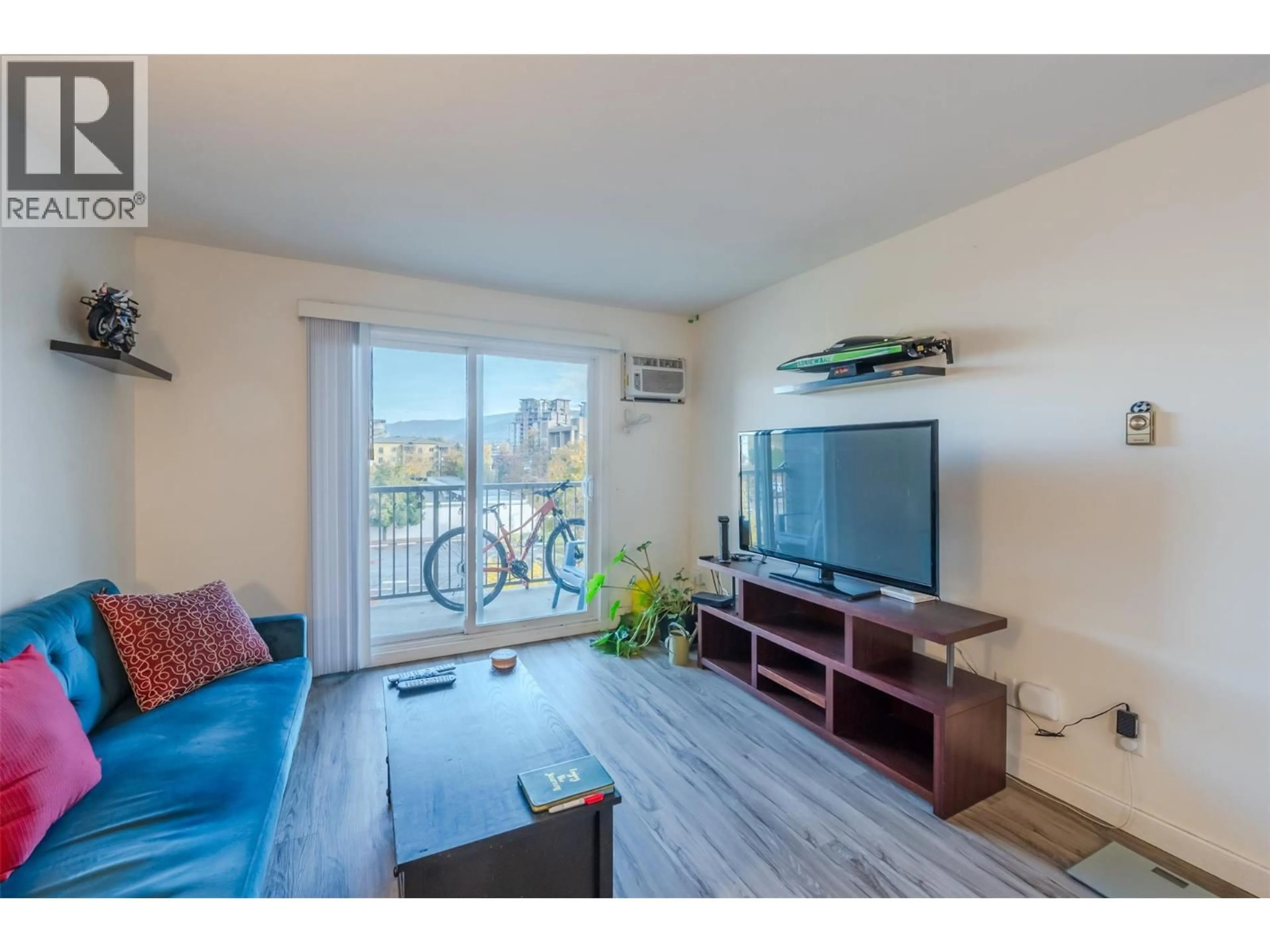 Living room with furniture, wood/laminate floor for 411 - 130 SKAHA PLACE, Penticton British Columbia V2A7J6