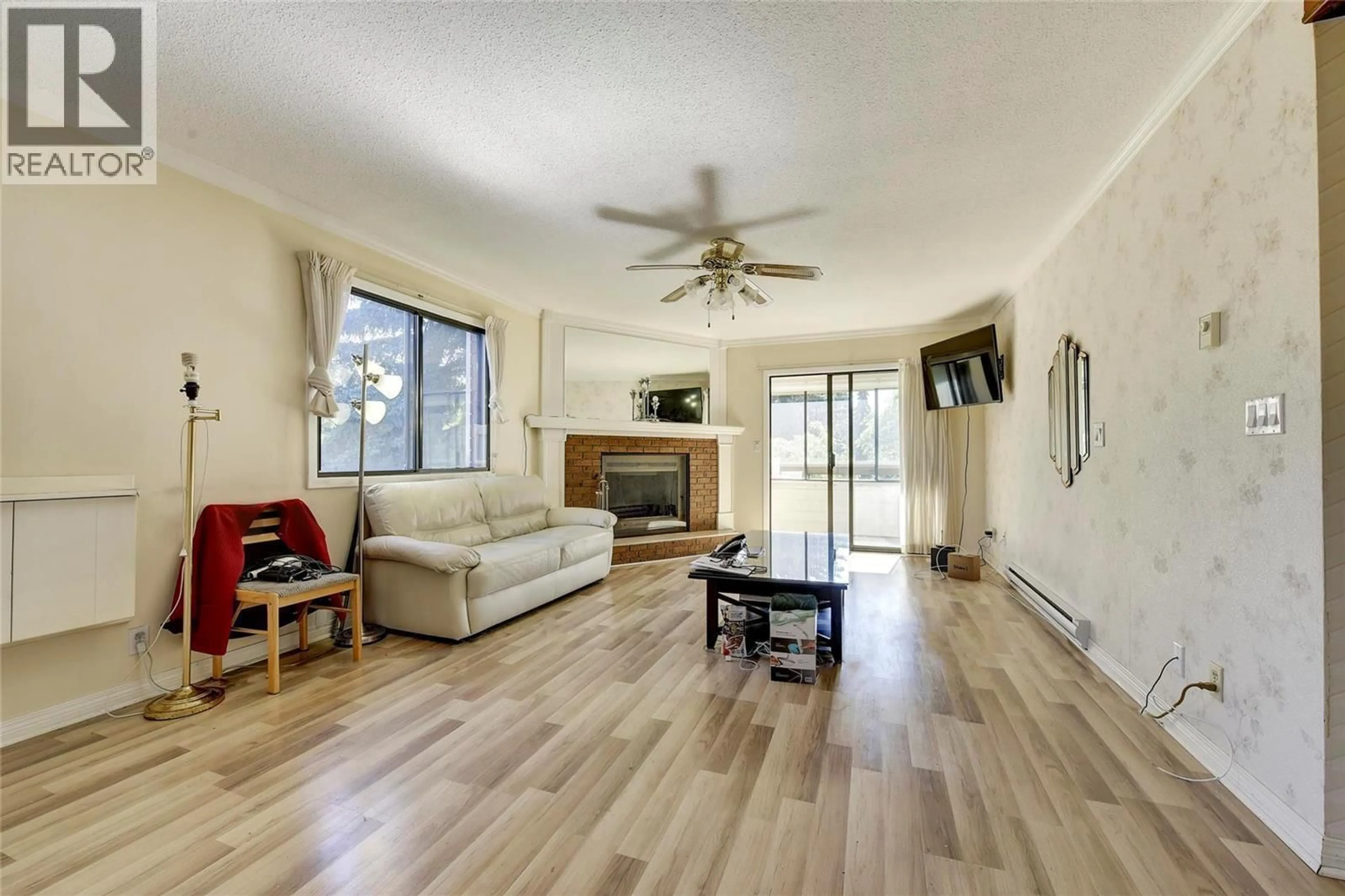 Living room with furniture, wood/laminate floor for 214 - 1075 BERNARD AVENUE, Kelowna British Columbia V1Y6P7