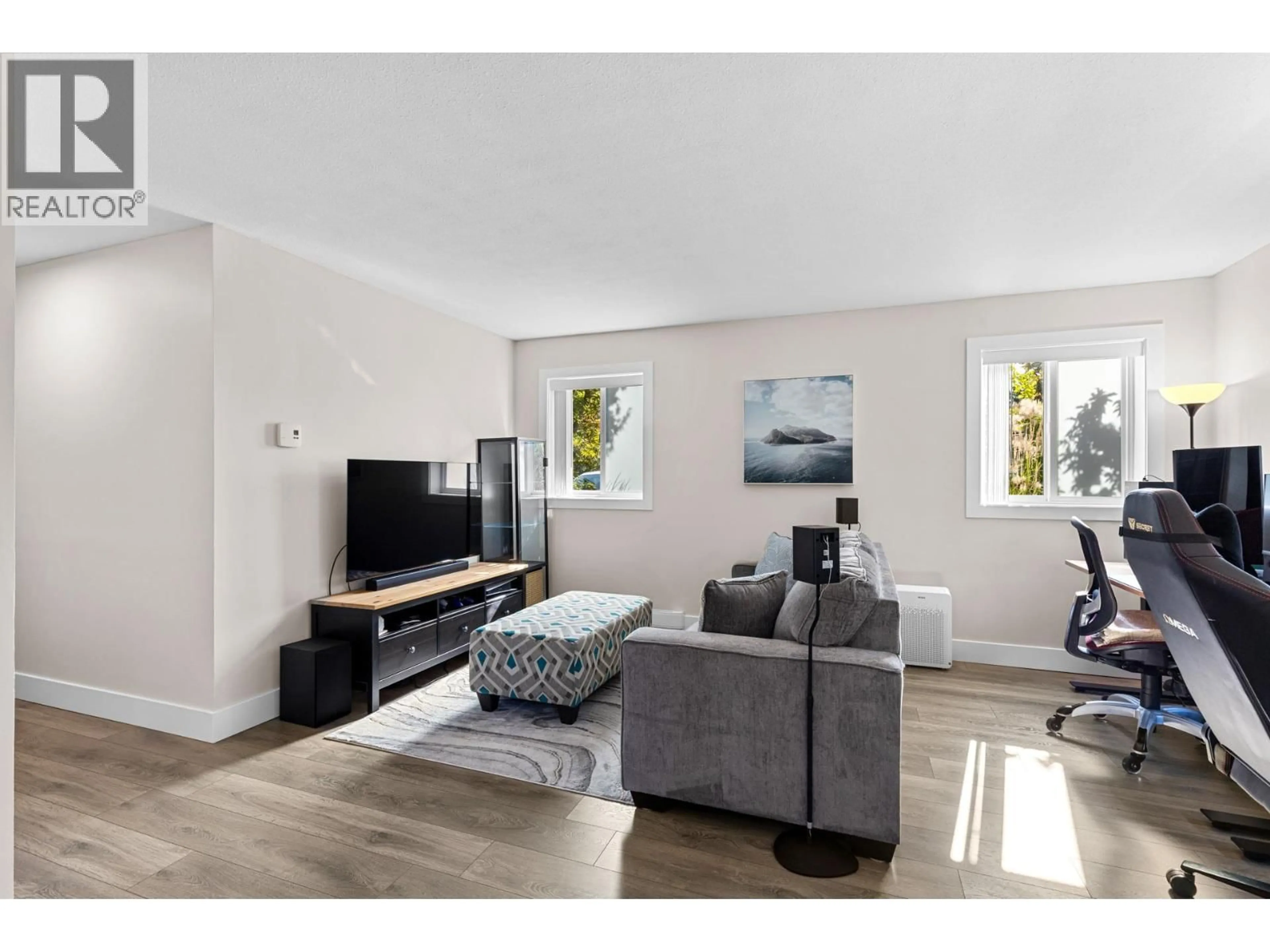 Living room with furniture, wood/laminate floor for 102 - 2035 BARON ROAD, Kelowna British Columbia V1X7G3