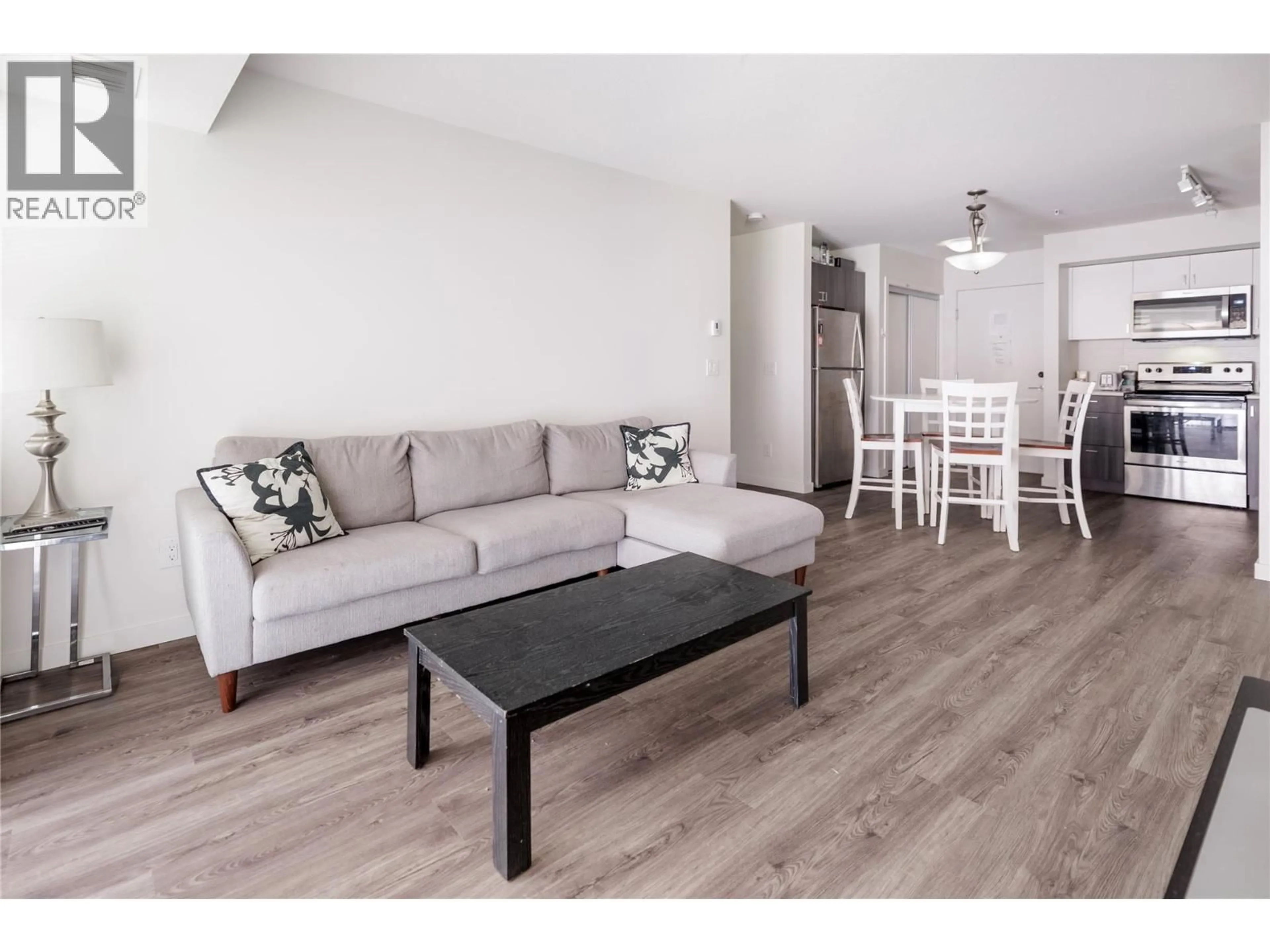 Living room with furniture, wood/laminate floor for 107 - 655 ACADEMY WAY, Kelowna British Columbia V1V0C8