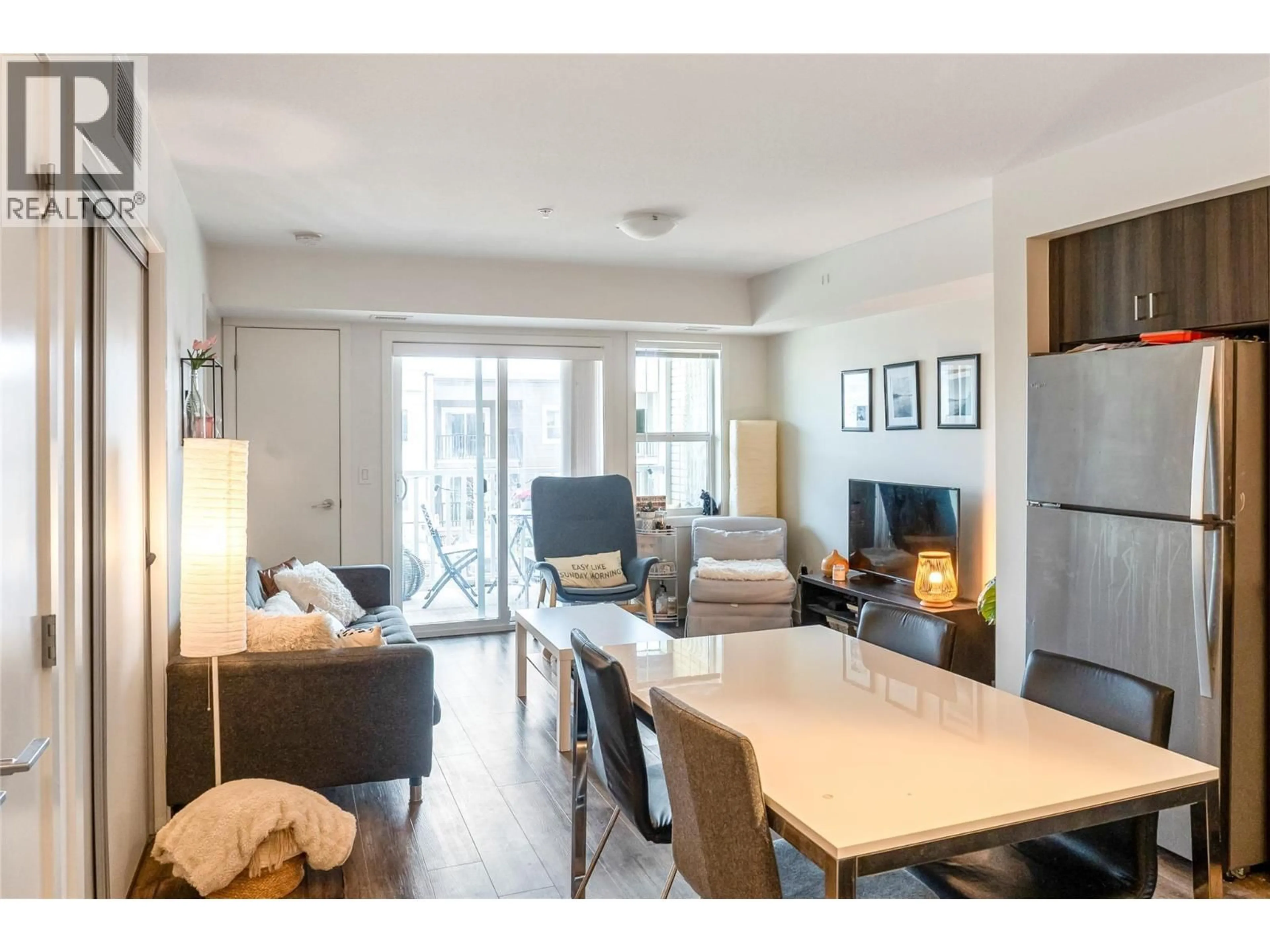 Living room with furniture, wood/laminate floor for 121 - 655 ACADEMY WAY, Kelowna British Columbia V1V0A2