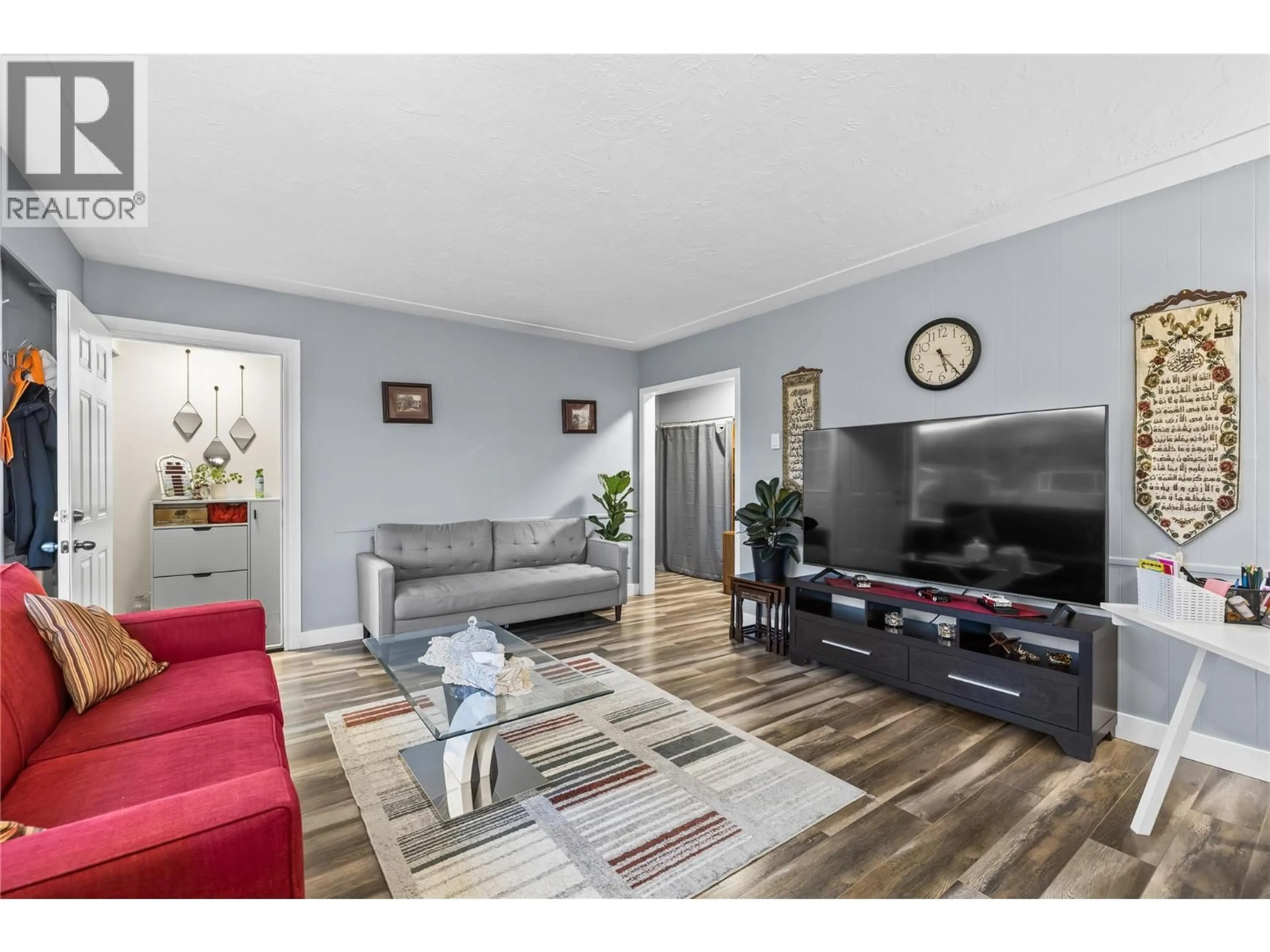 Living room with furniture, wood/laminate floor for 205 HOMER ROAD, Kelowna British Columbia V1X3Z6