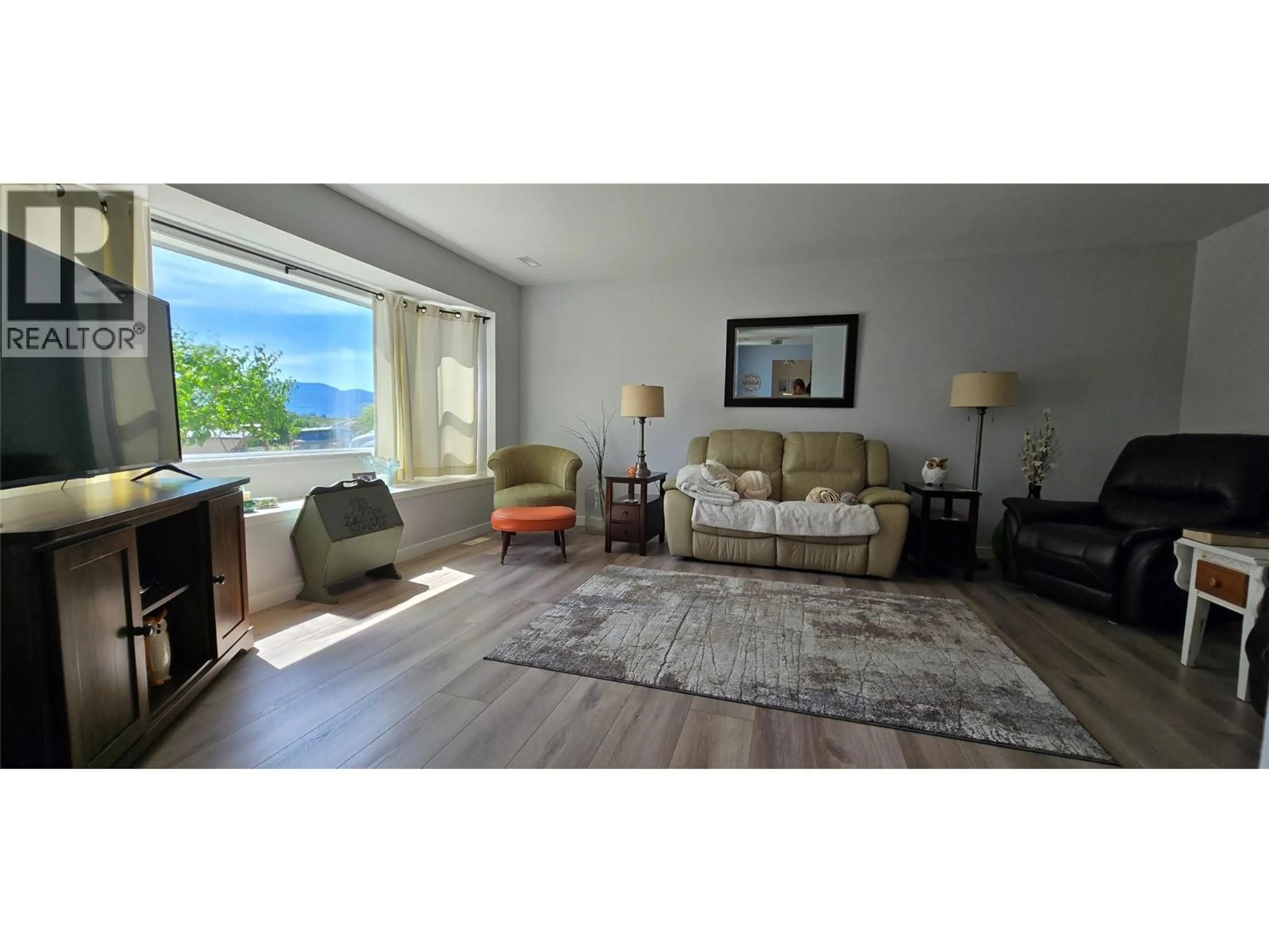 Living room with furniture, wood/laminate floor for 9517 62 AVENUE, Osoyoos British Columbia V0H1V1