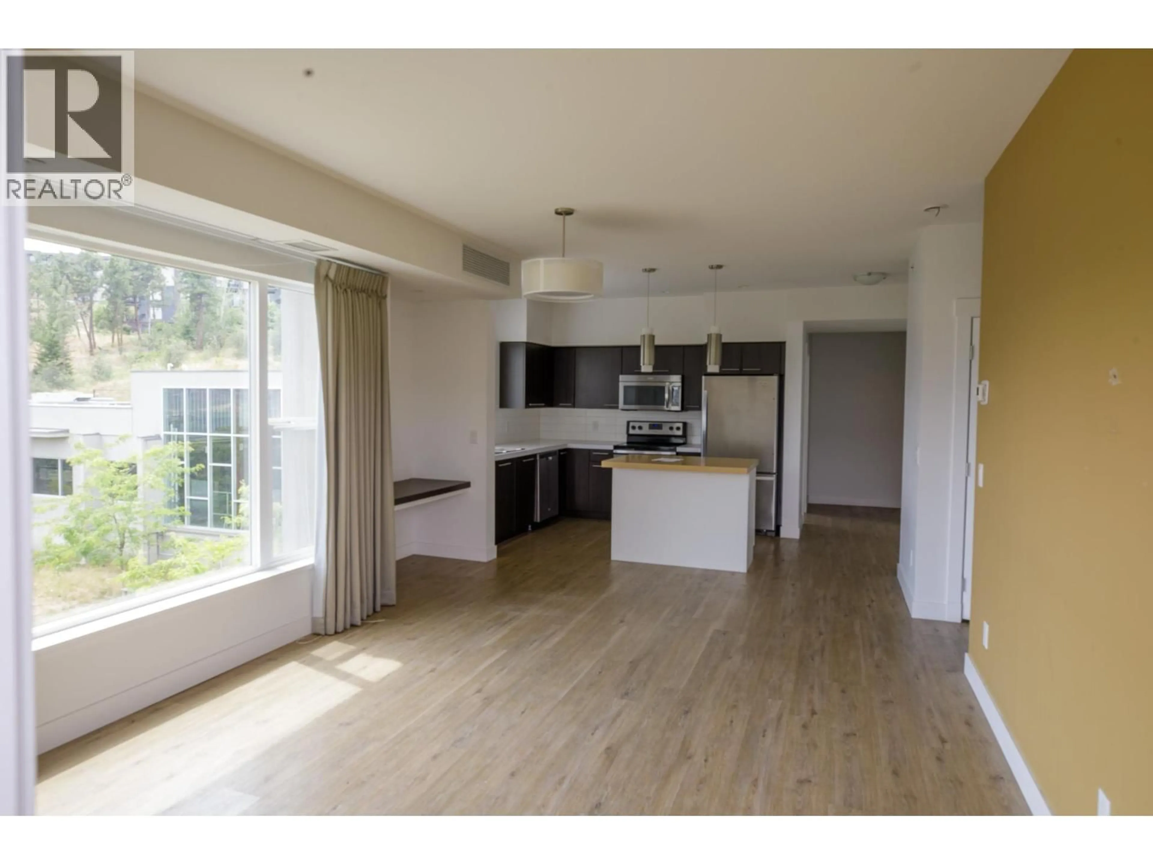 Open concept kitchen, wood/laminate floor for 307 - 985 ACADEMY WAY, Kelowna British Columbia V1V3C8