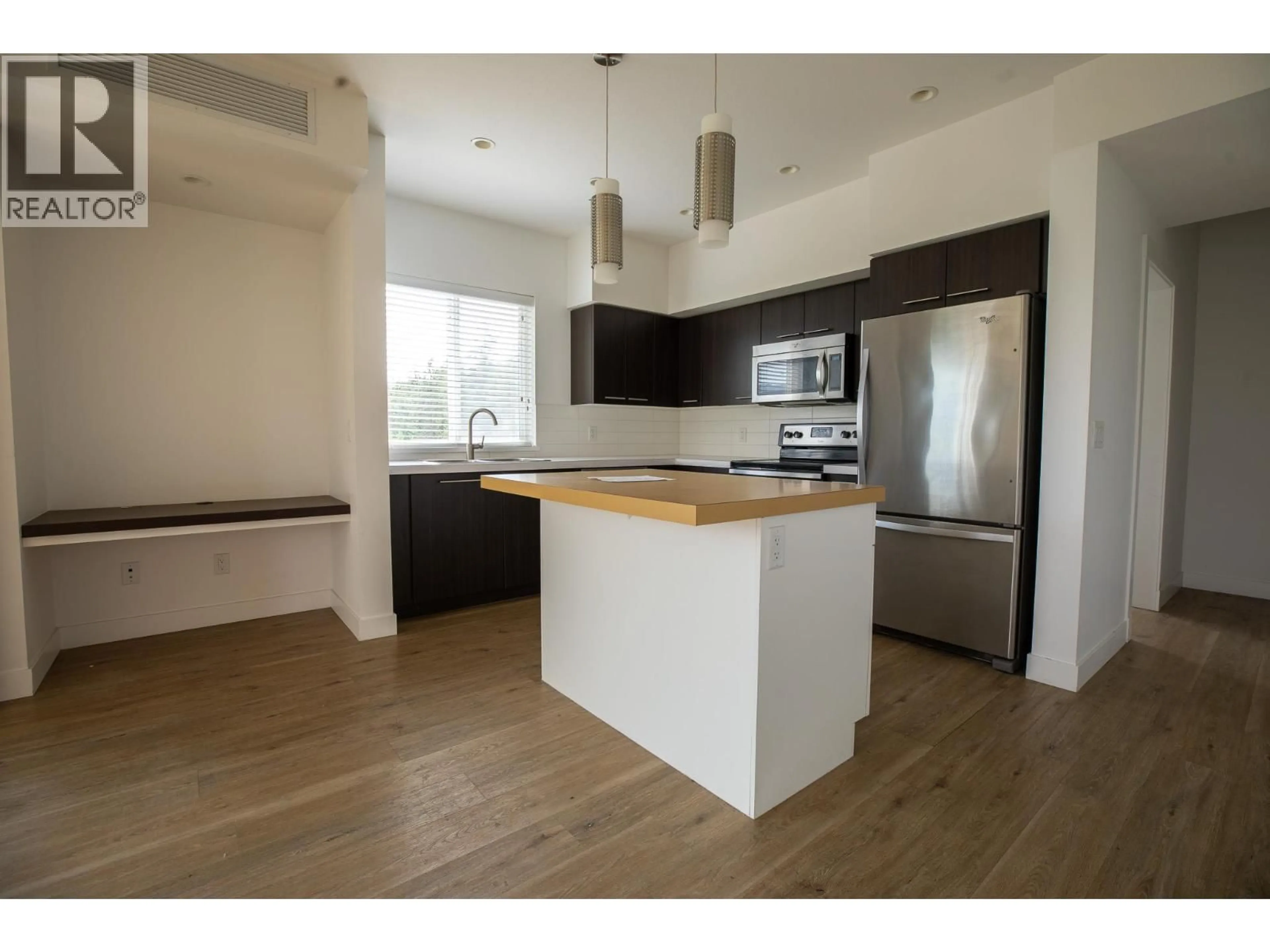 Open concept kitchen, wood/laminate floor for 307 - 985 ACADEMY WAY, Kelowna British Columbia V1V3C8
