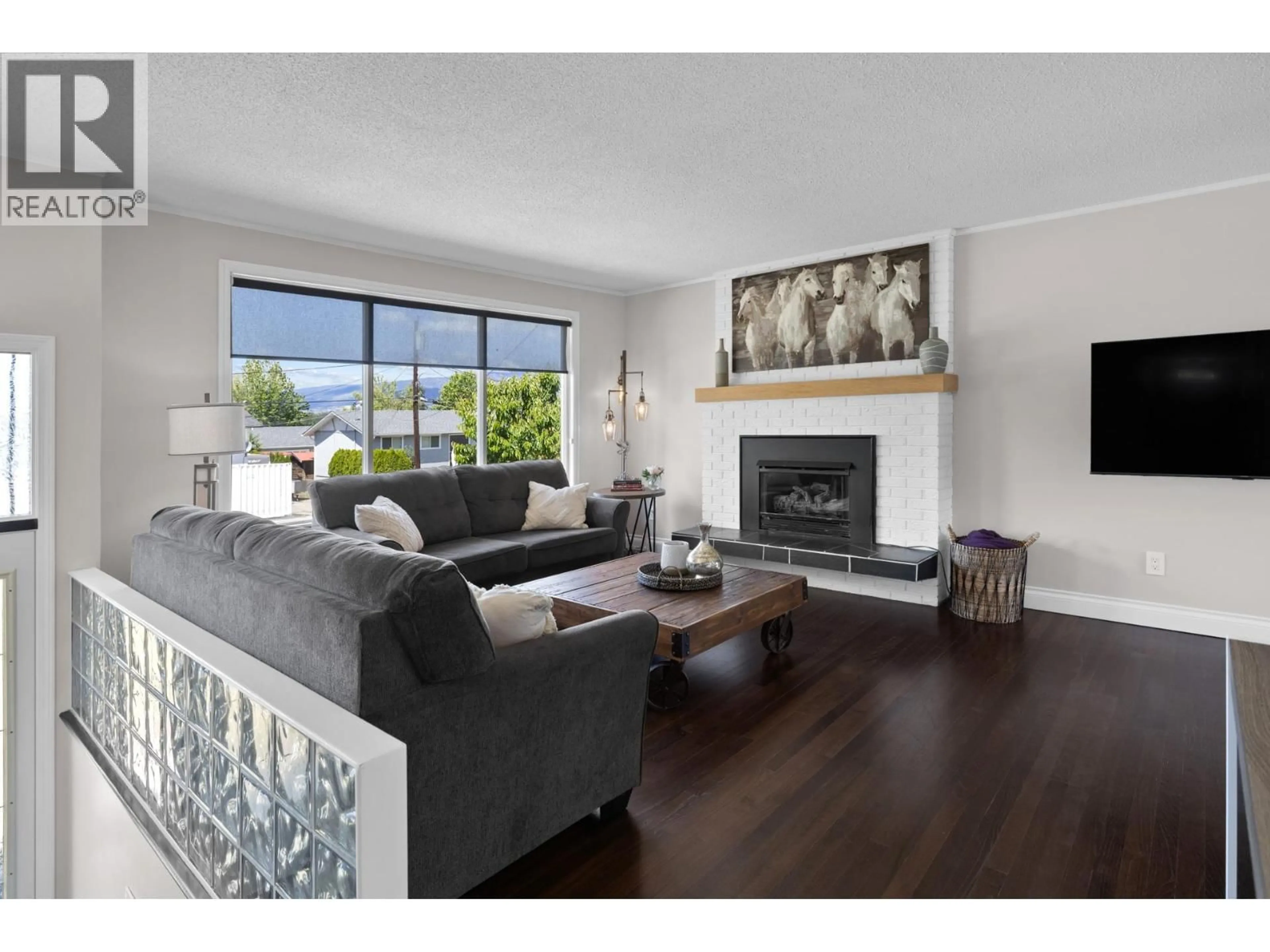 Living room with furniture, wood/laminate floor for 4479 WASILOW ROAD, Kelowna British Columbia V1W1R7