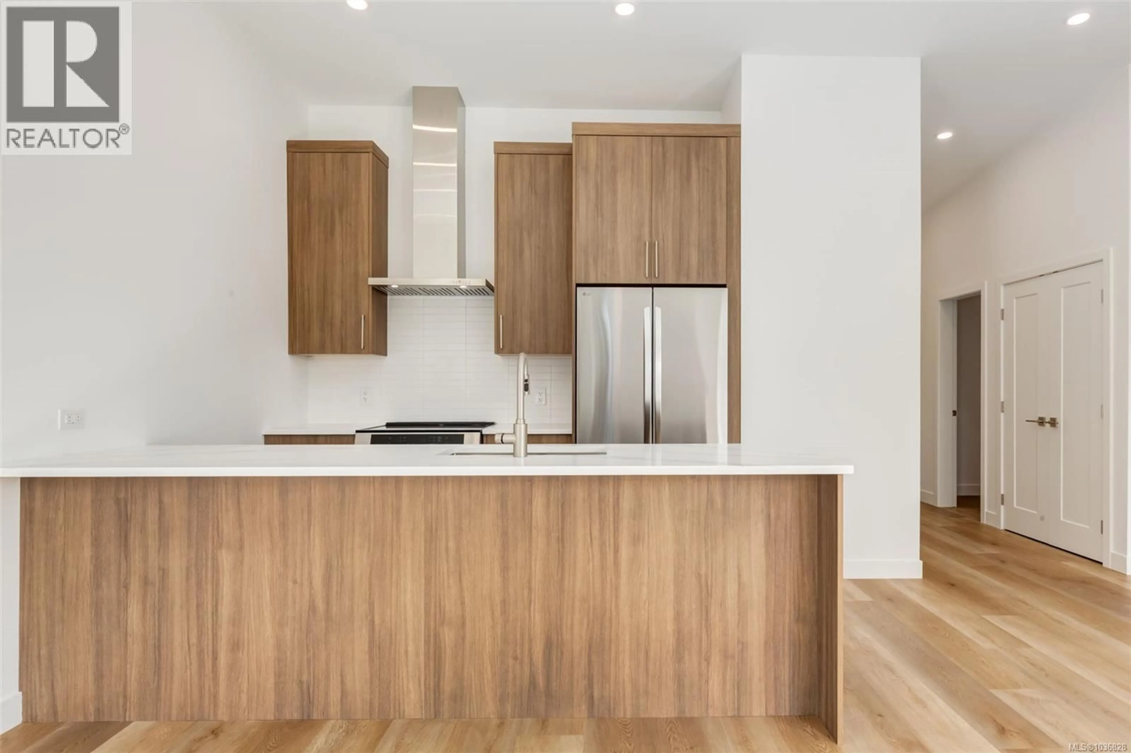 Open concept kitchen, wood/laminate floor for 203 - 7181 LANTZVILLE ROAD, Lantzville British Columbia V0R2H0
