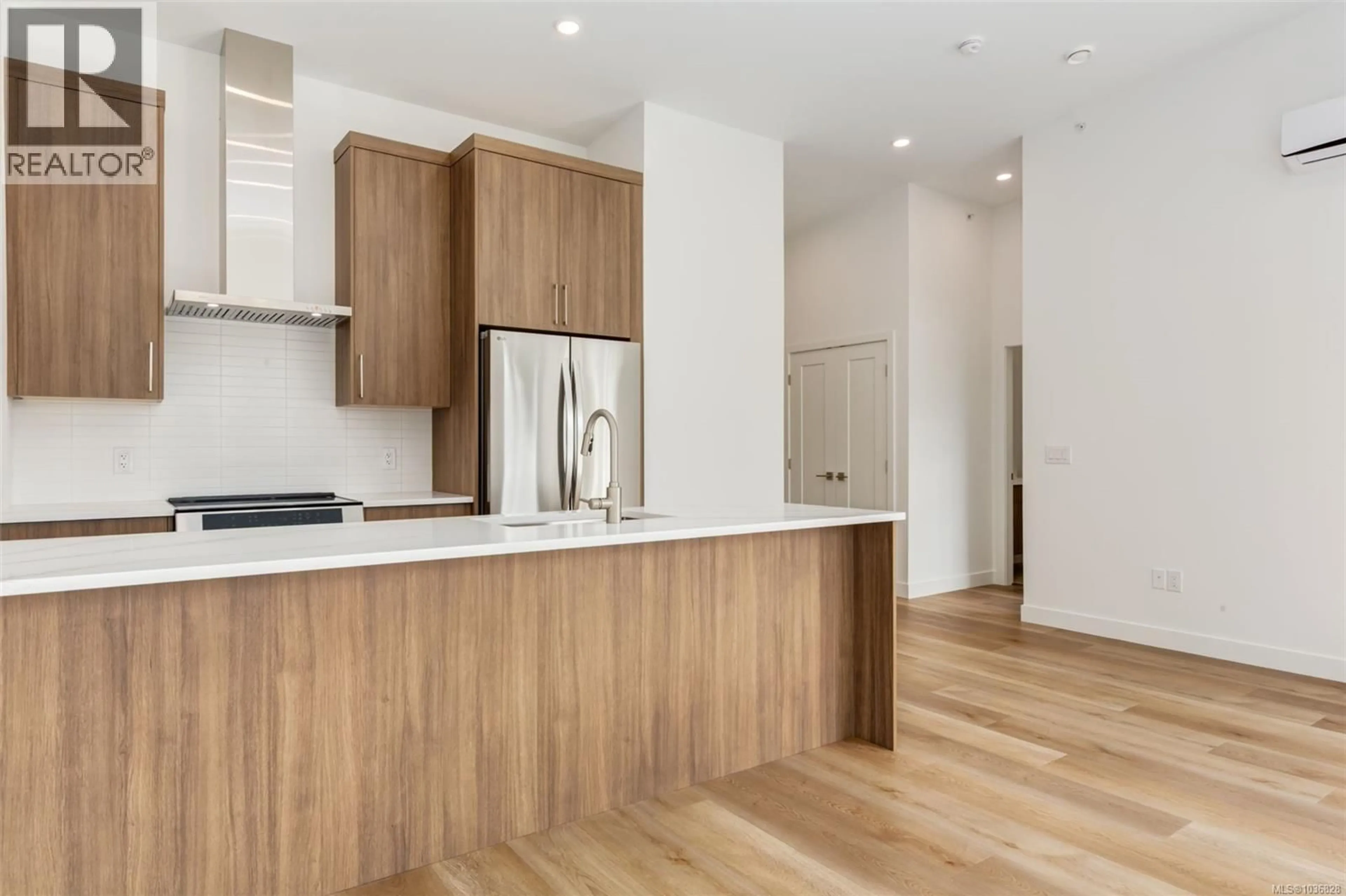 Open concept kitchen, wood/laminate floor for 203 - 7181 LANTZVILLE ROAD, Lantzville British Columbia V0R2H0