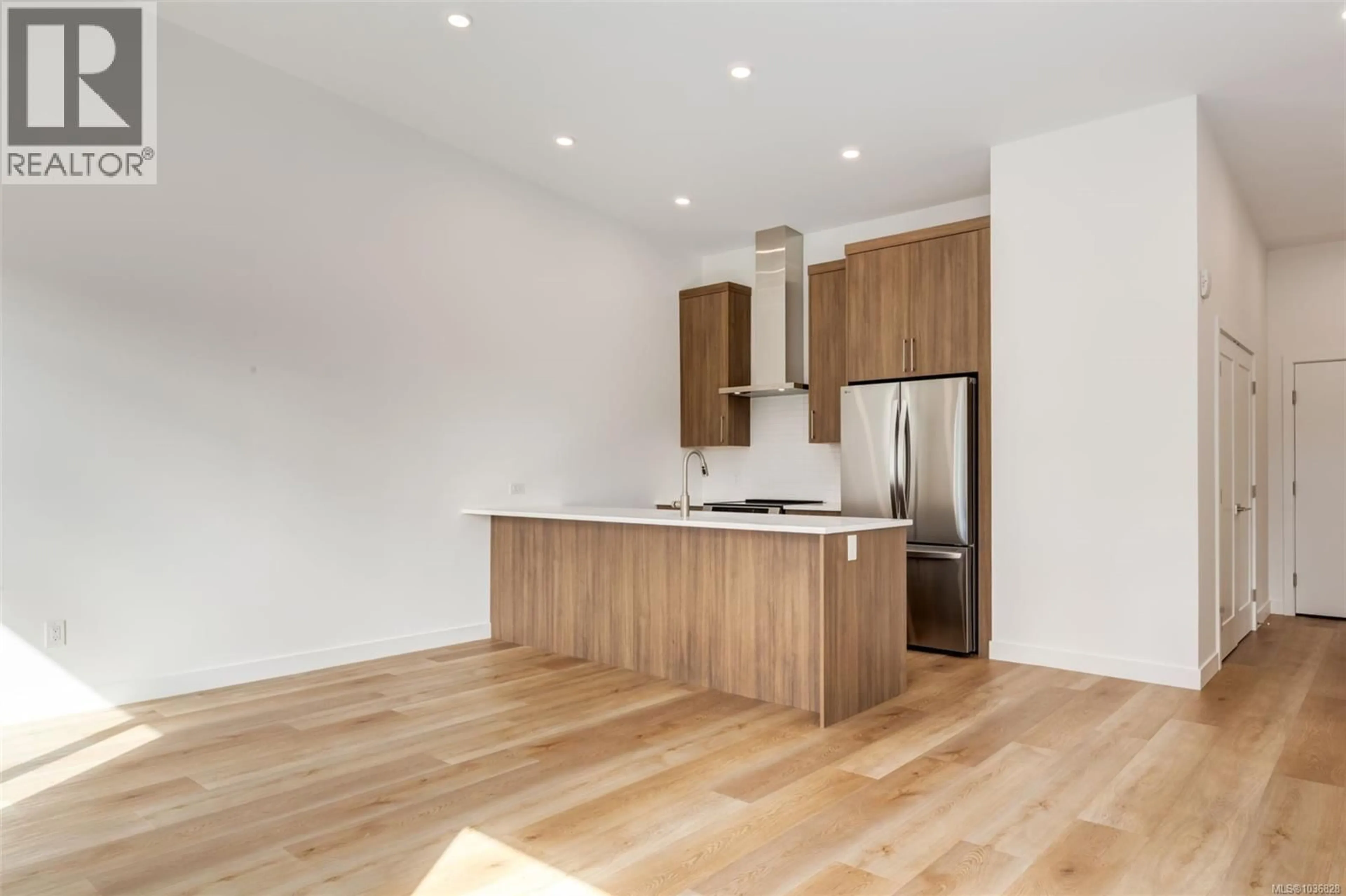 Open concept kitchen, wood/laminate floor for 203 - 7181 LANTZVILLE ROAD, Lantzville British Columbia V0R2H0