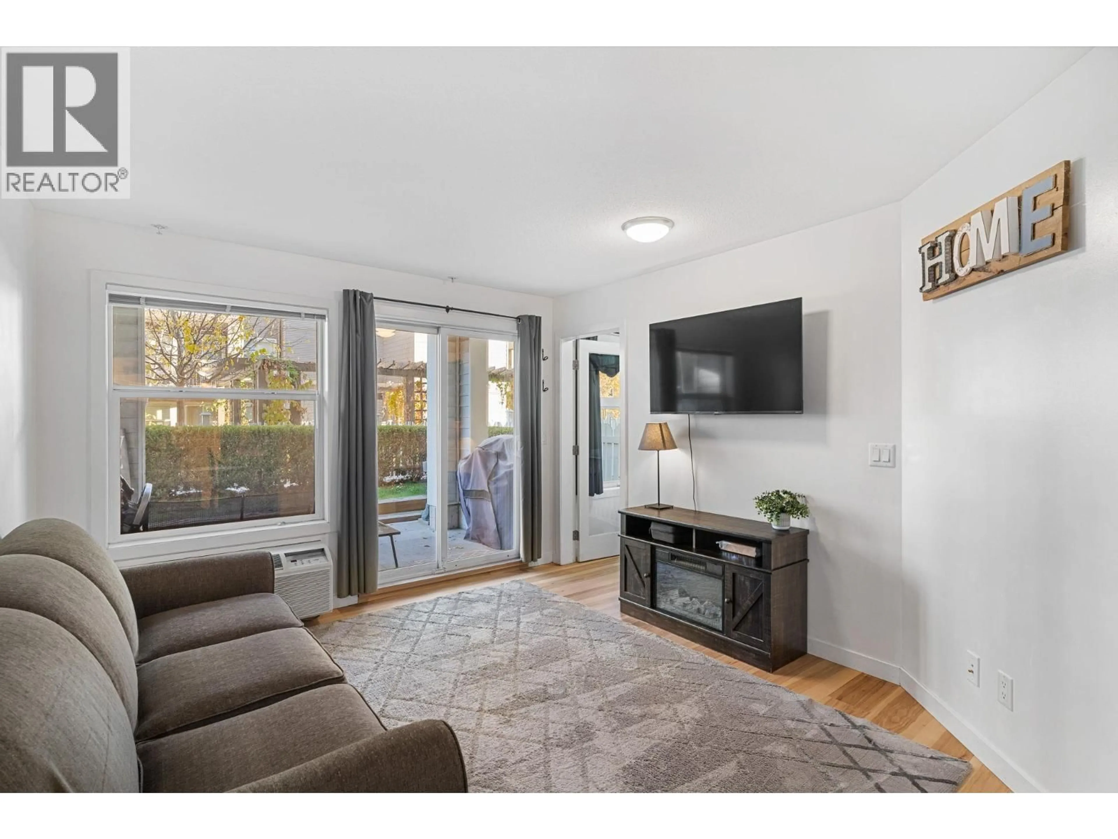 Living room with furniture, wood/laminate floor for 104 - 539 YATES ROAD, Kelowna British Columbia V1V2T8