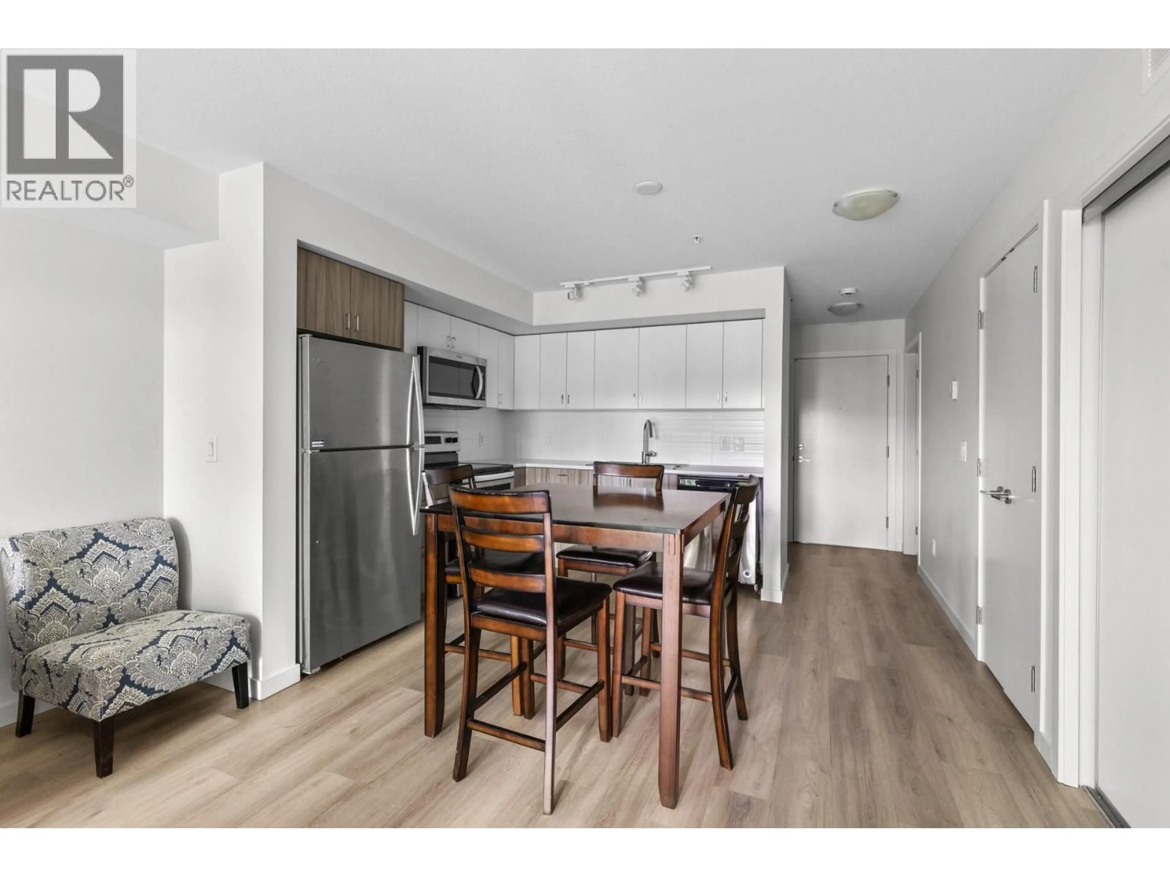 Open concept kitchen, wood/laminate floor for 105 - 695 ACADEMY WAY, Kelowna British Columbia V1V0C7