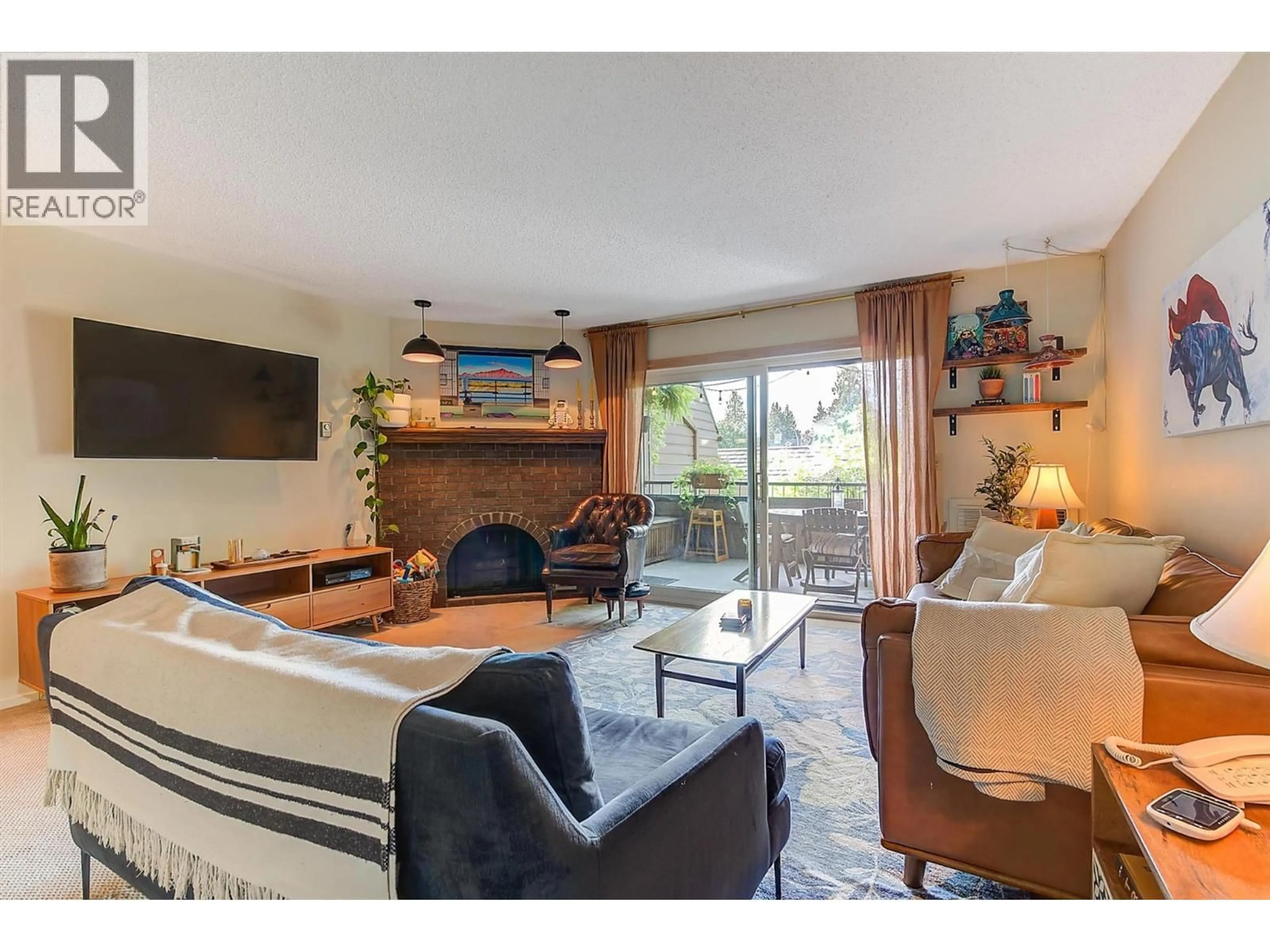Living room with furniture, wood/laminate floor for 205 - 983 BERNARD AVENUE, Kelowna British Columbia V1Y6P7